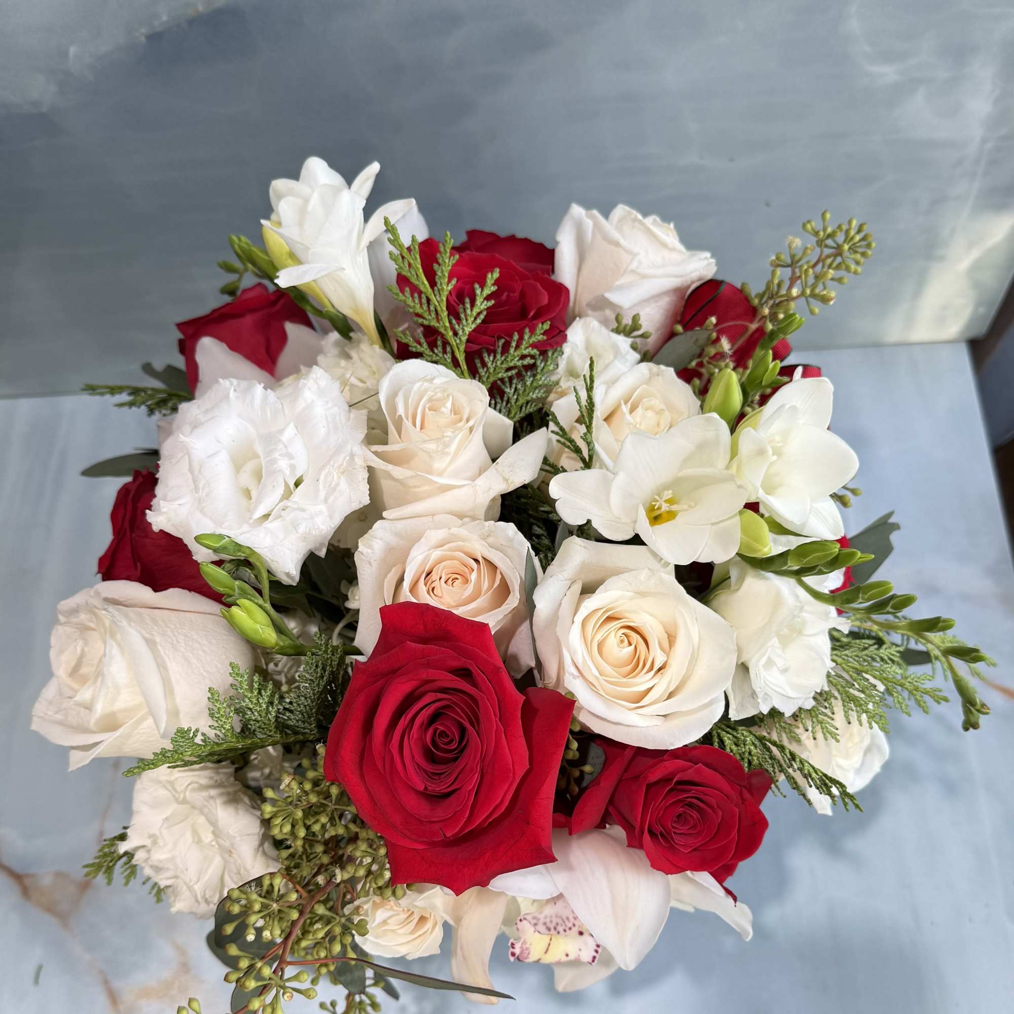 This floral arrangement is elegant, classic, and warmly festive. A lush mix