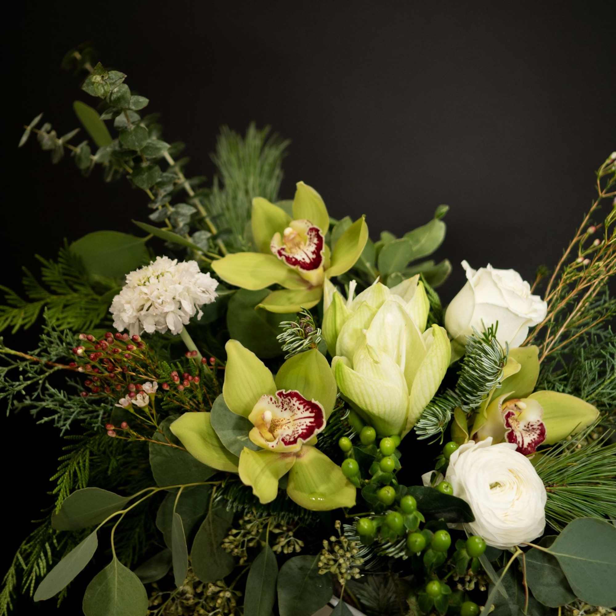 This elegant winter arrangement captures the serene beauty of a snow-dusted landscape.