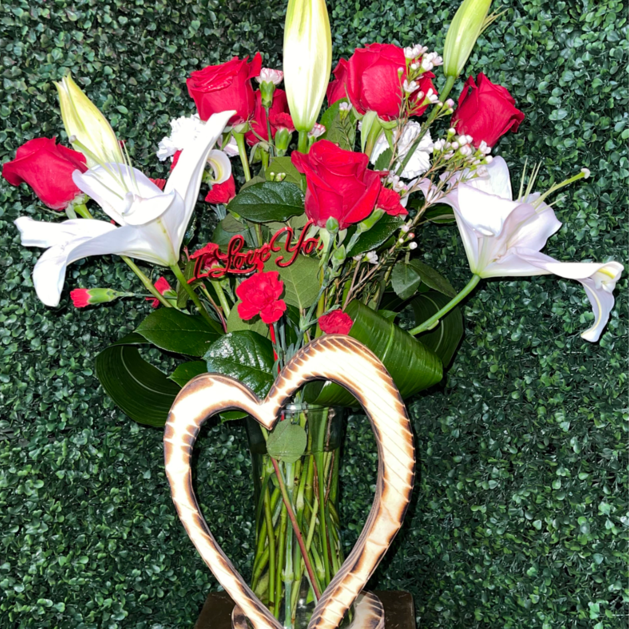 A lovely wood-colored vase adorned with a wooden heart, filled with classic