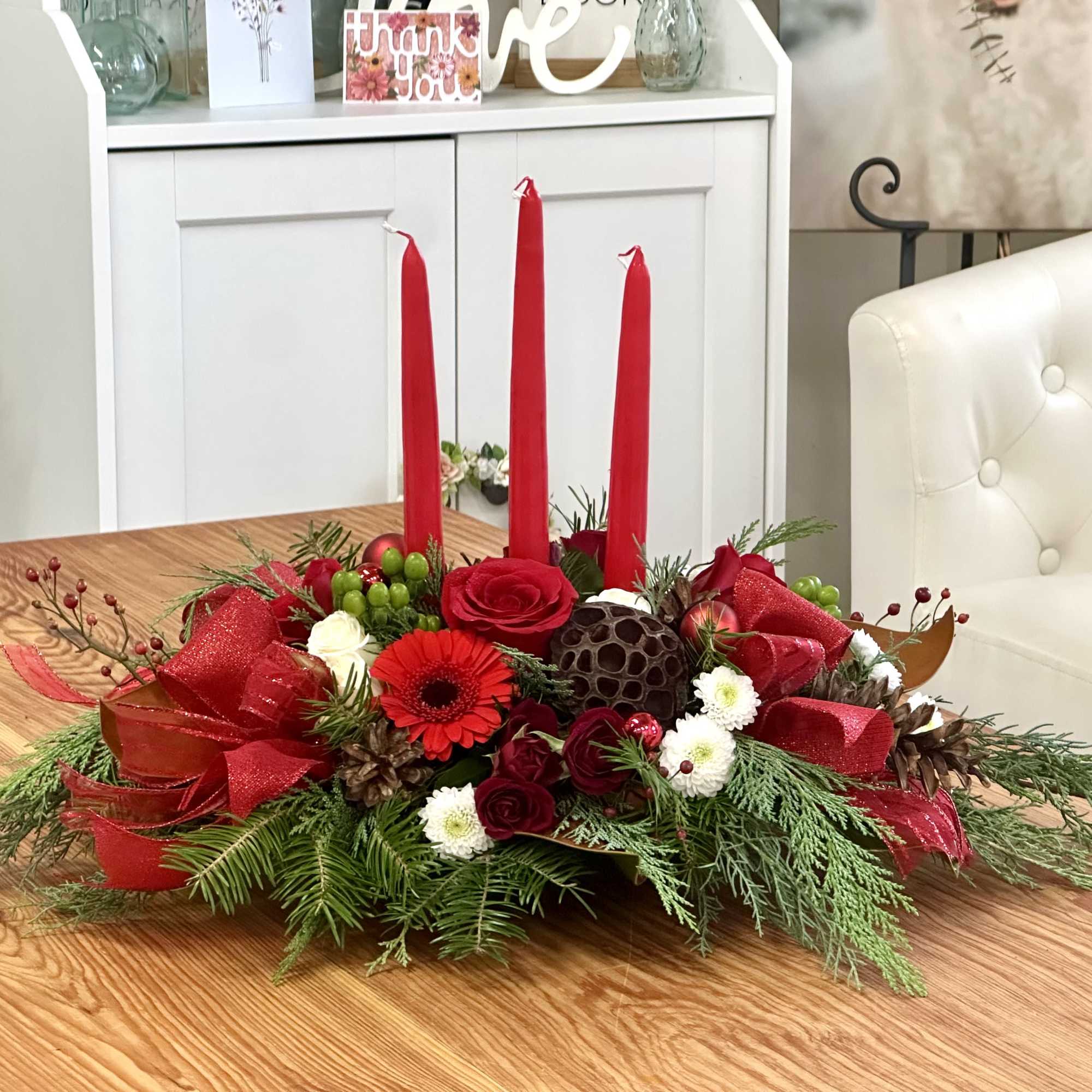 Elevate your holiday celebrations with the Evergreen Candlelight Centerpiece by Westford Florist.