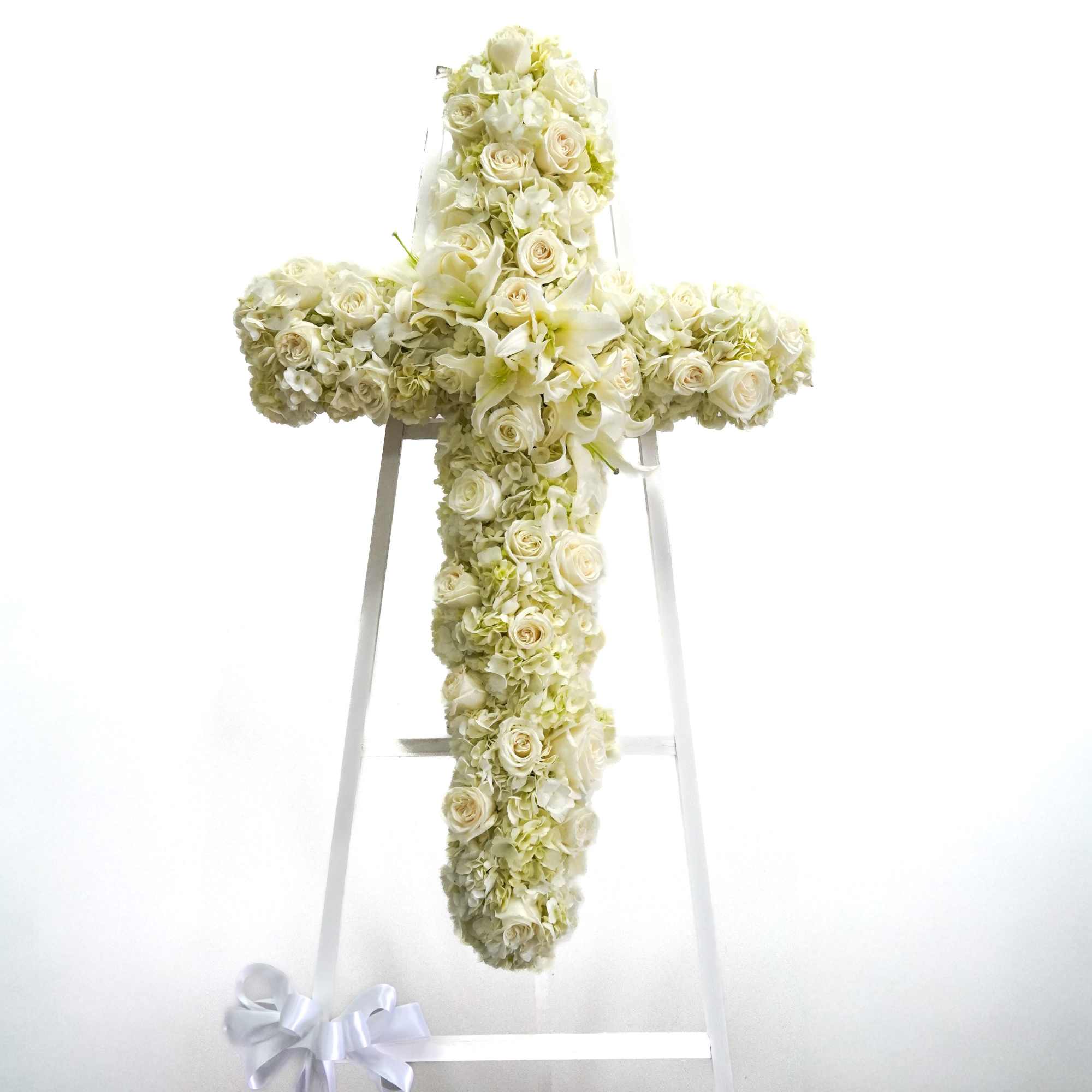 An all white tribute, this white cross funeral spray is pure and