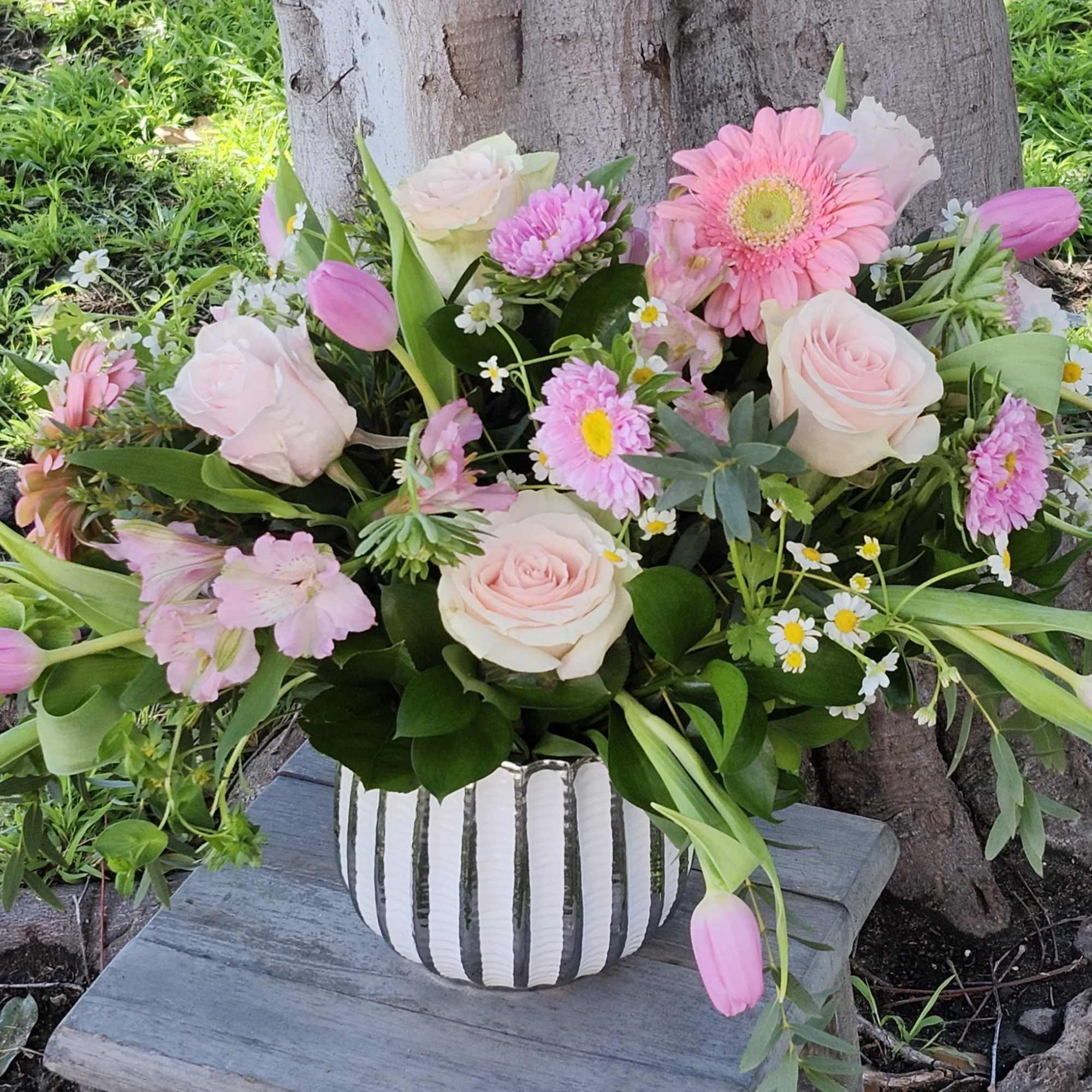 Enjoy a variety of pink spring blooms in a elegant vase, variety