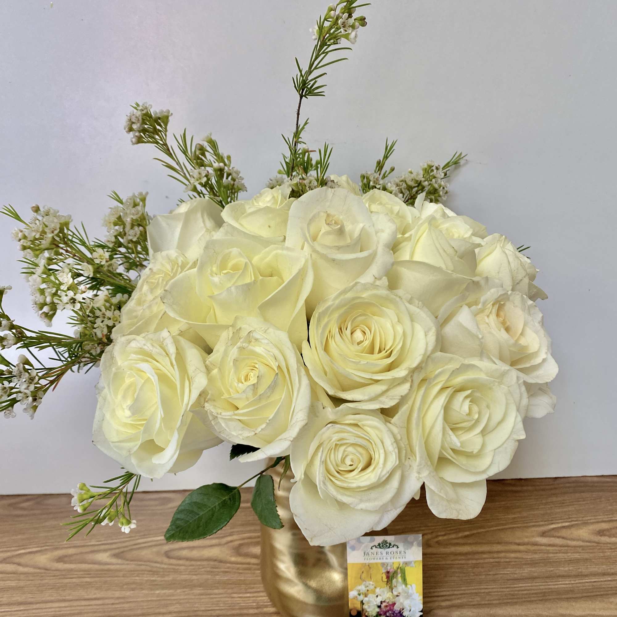 15 white roses in a gold vase 