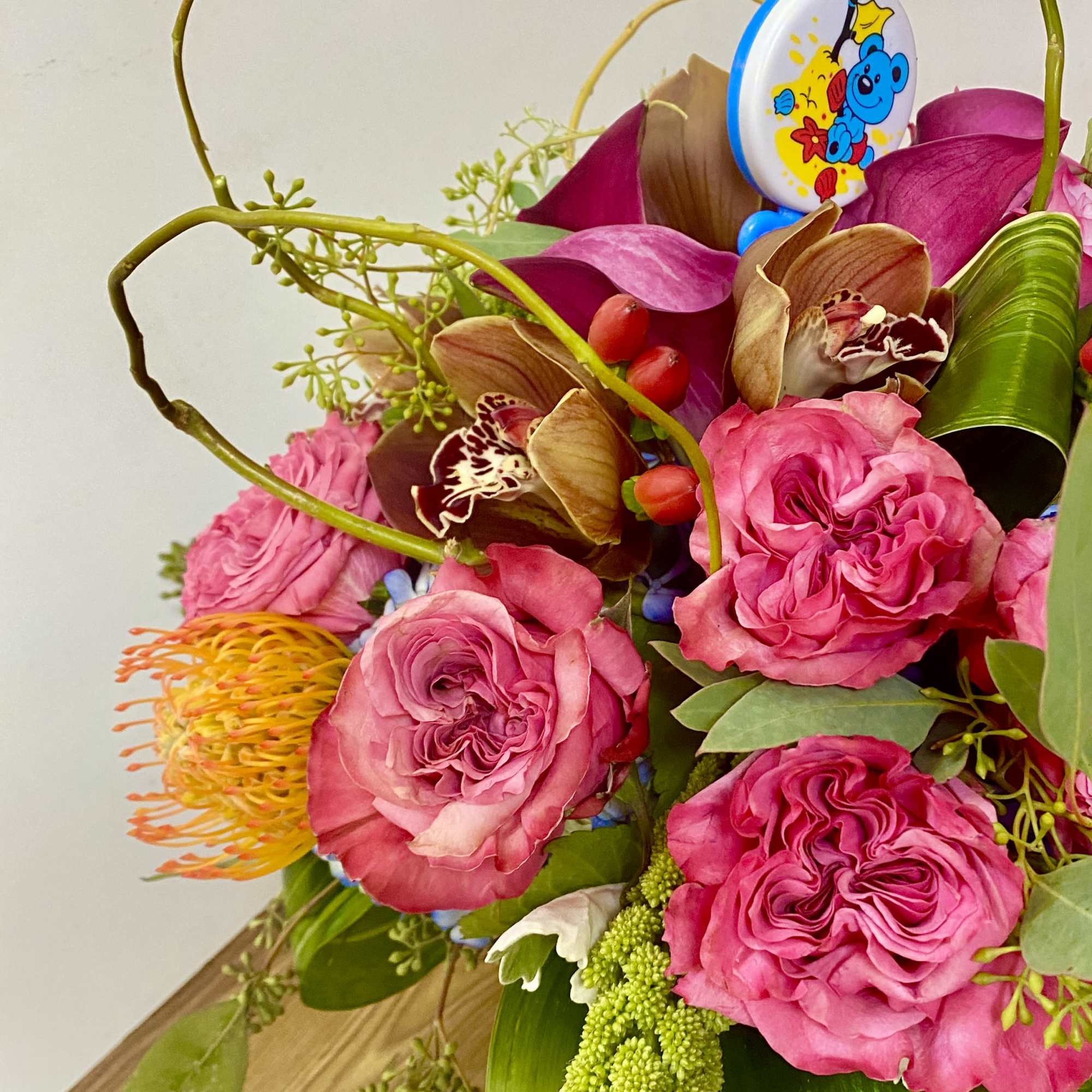 combinations off flowers in a glass vase with a sign IT'S A