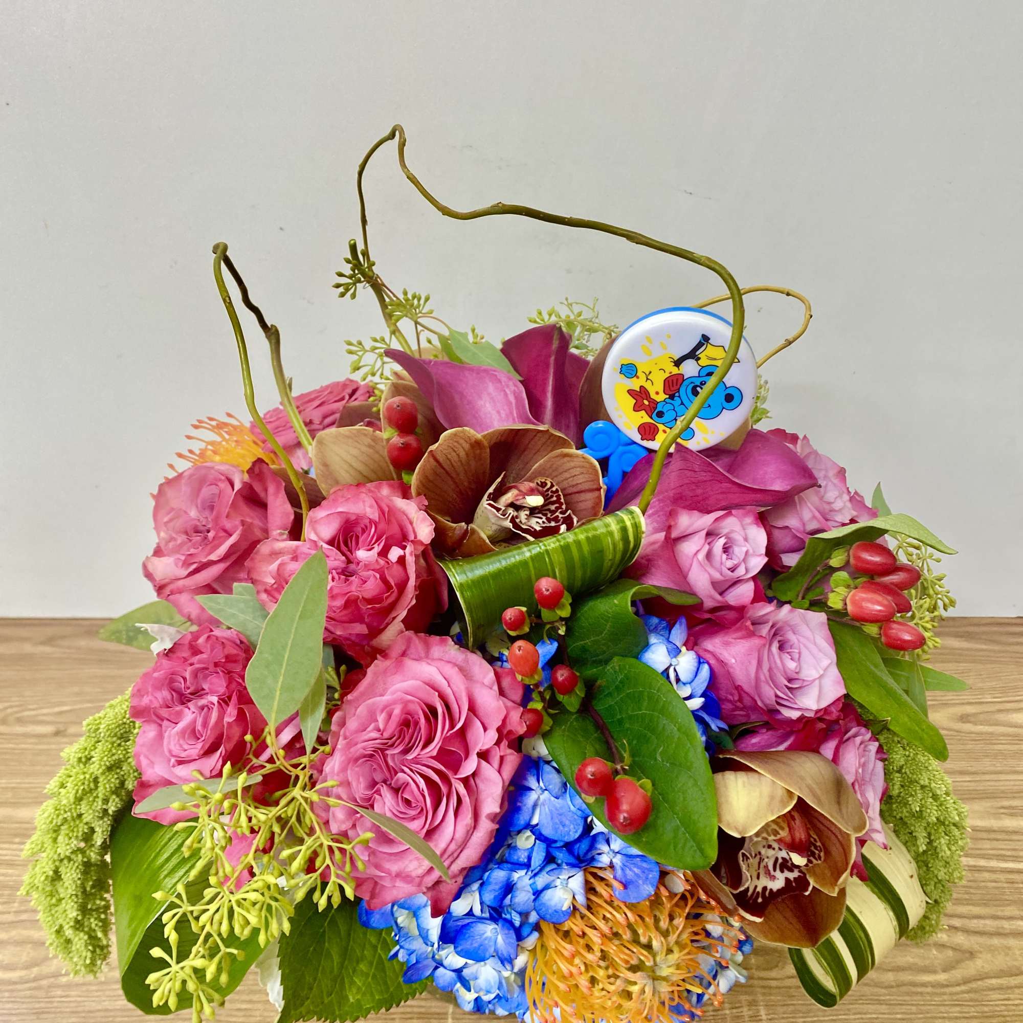 combinations off flowers in a glass vase with a sign IT'S A