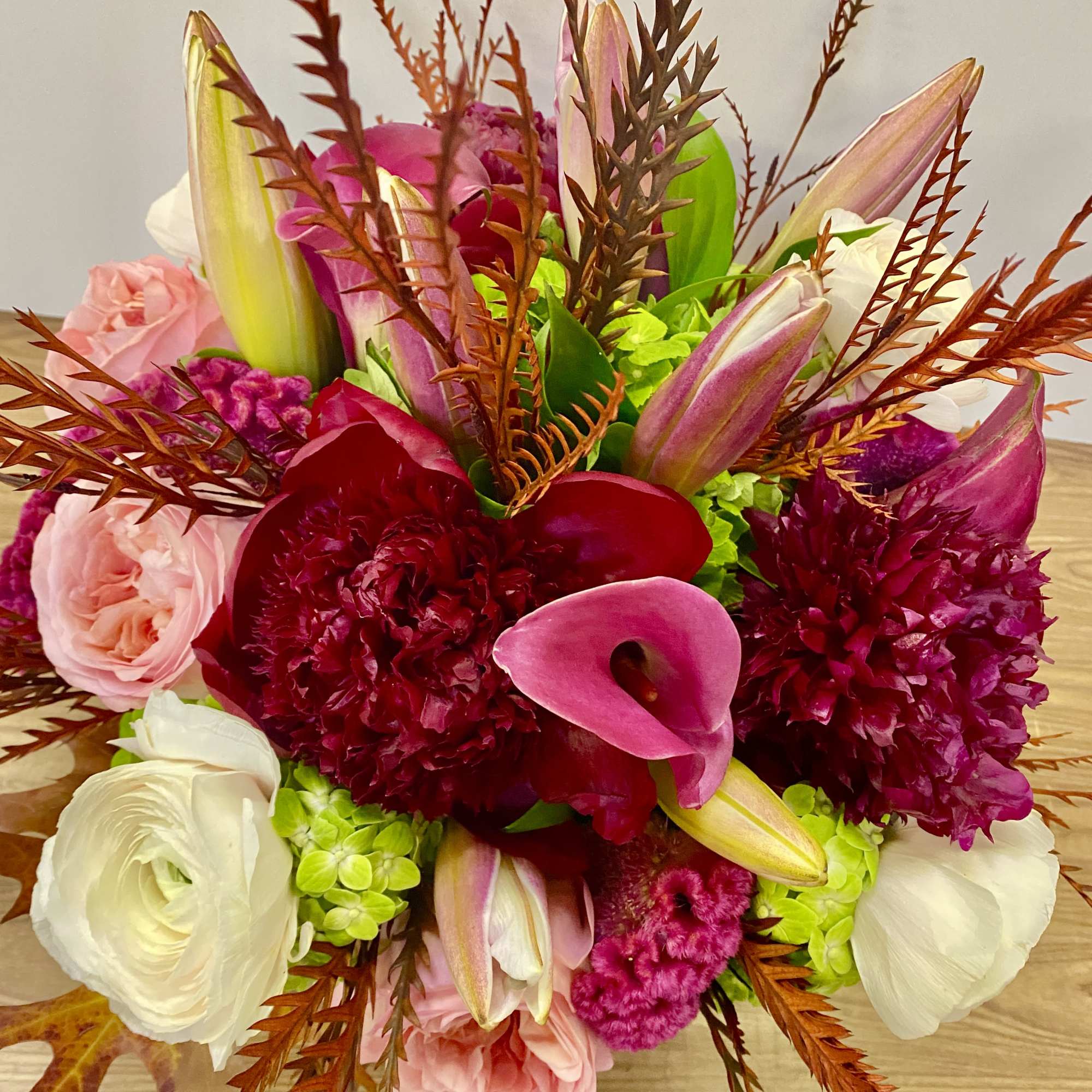 In a glass vasr combinations of pink roses white ranunculus and no