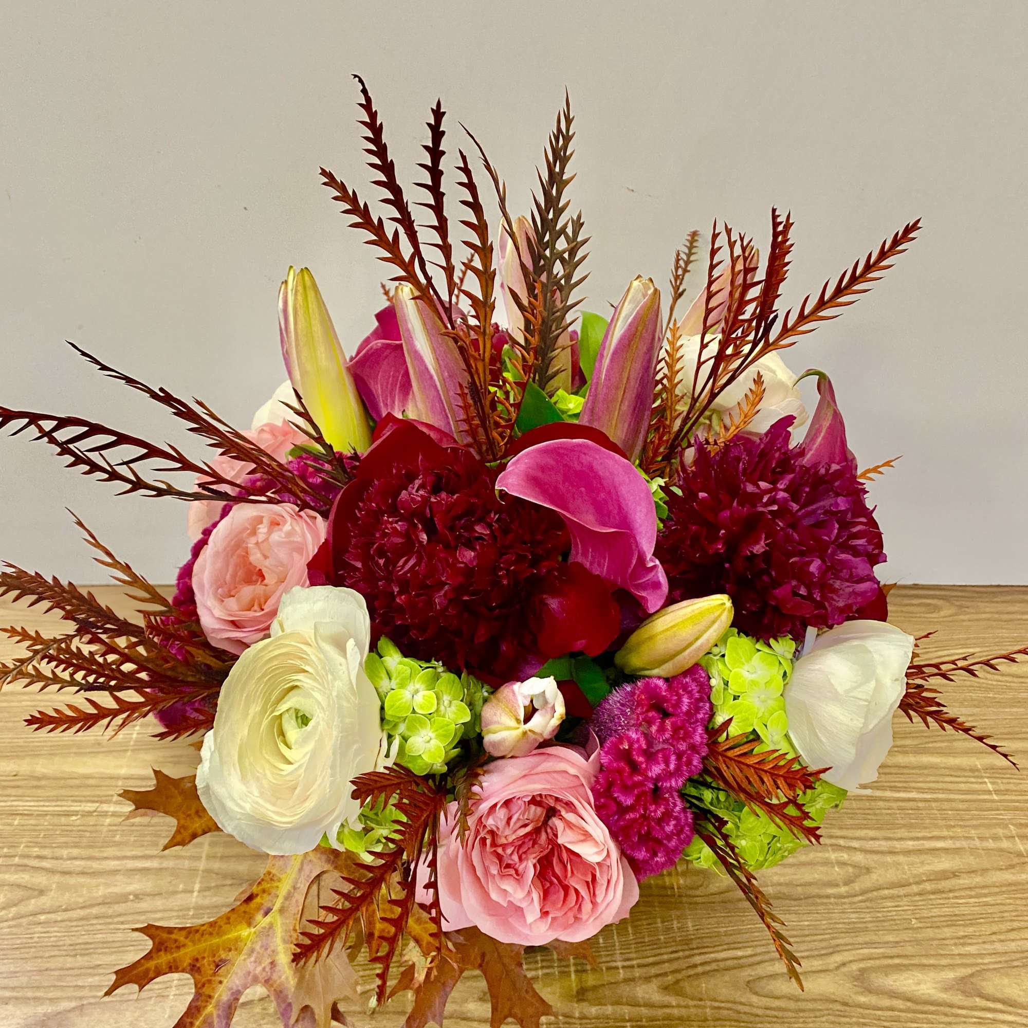 In a glass vasr combinations of pink roses white ranunculus and no