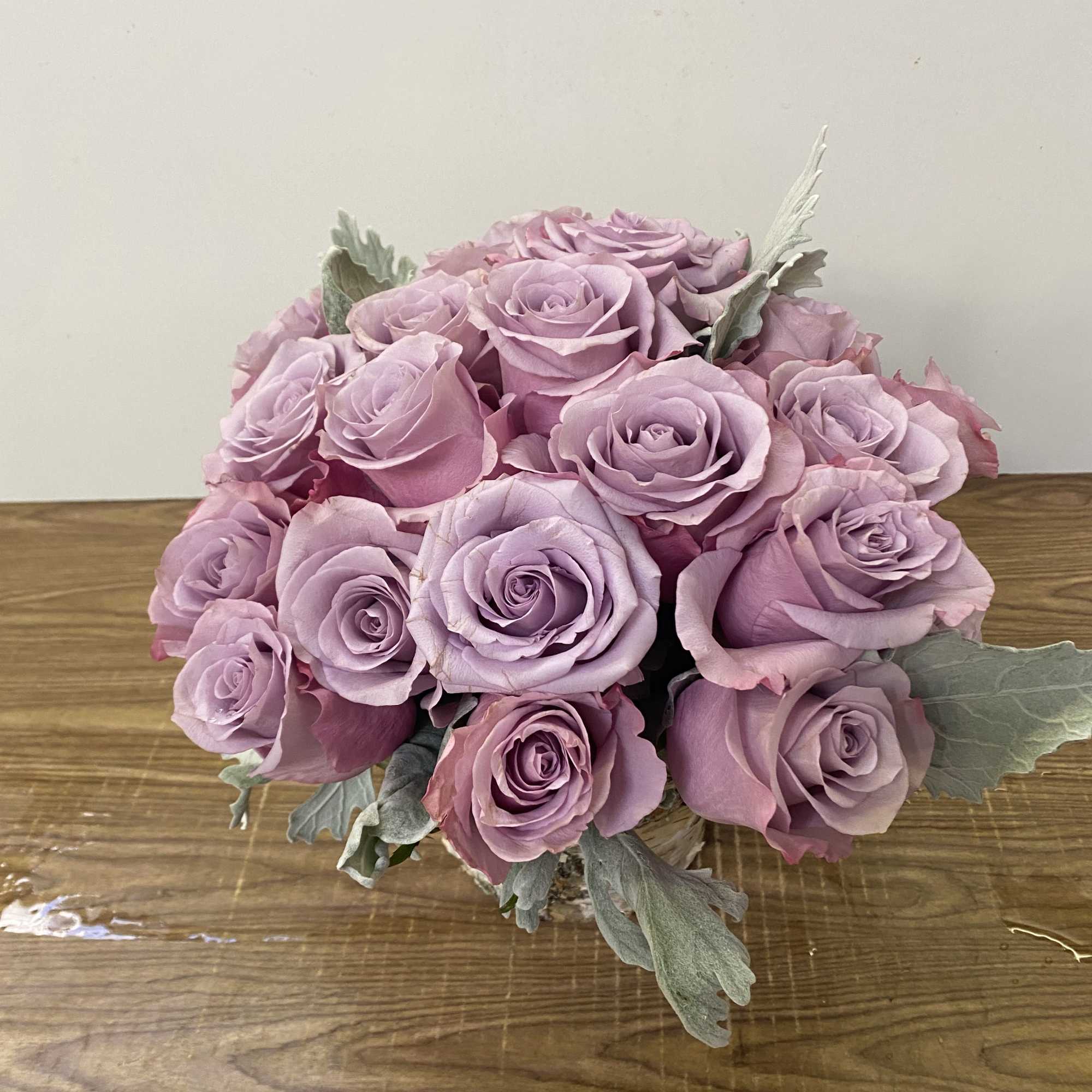 In a clear glass vase 15 lavender roses