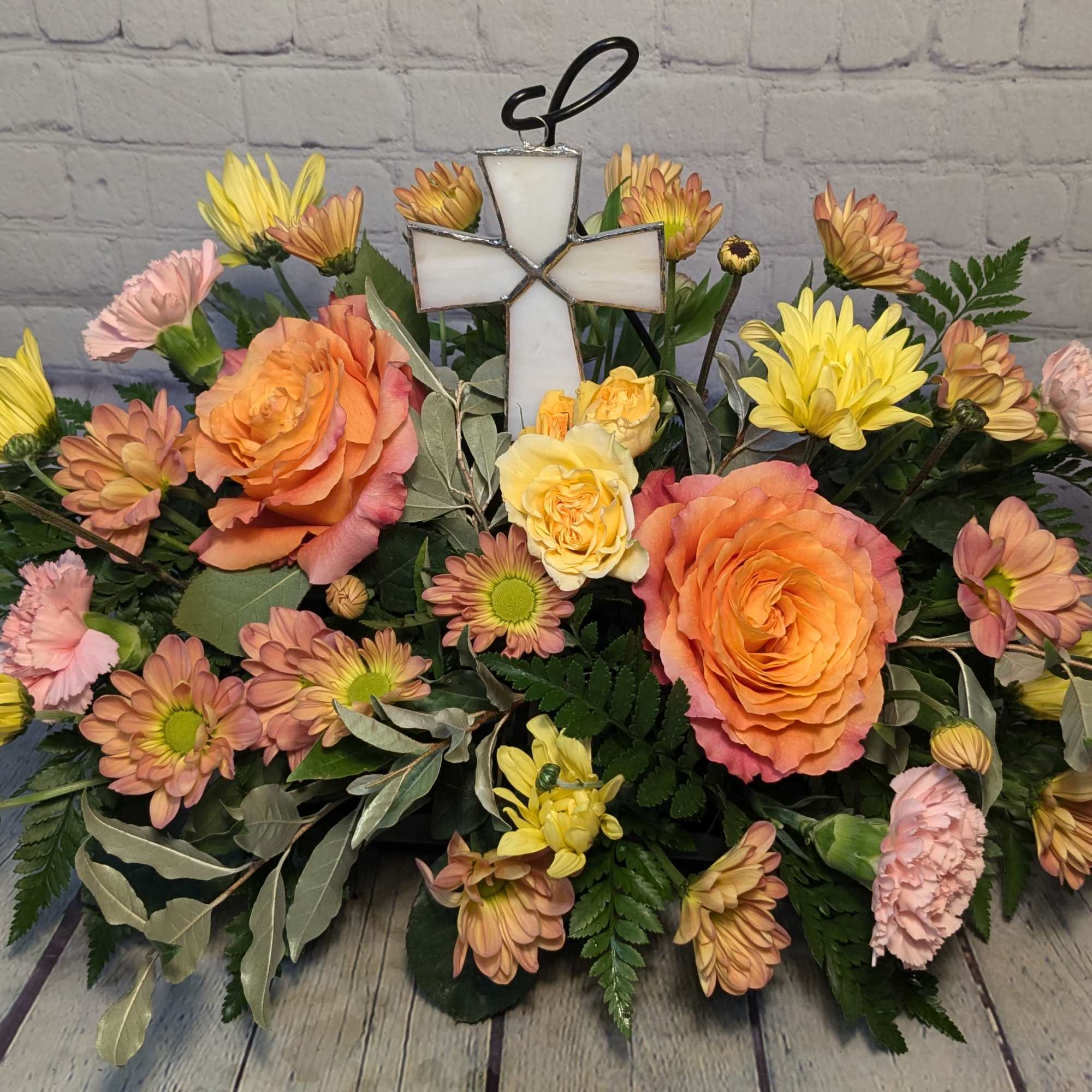 This bouquet features a locally made stained glass cross nestled amongst a