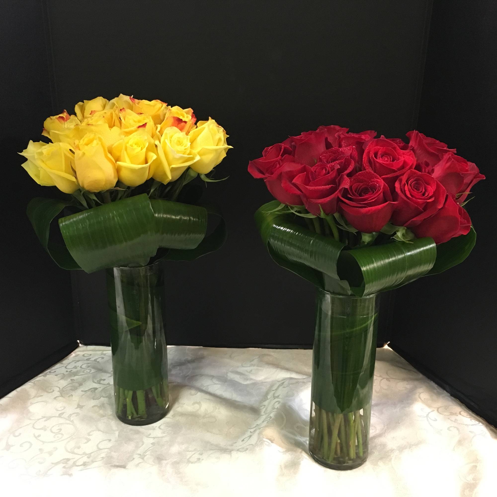  Long Stemmed Roses tightly arranged in a Cylinder vase..
Arrangement can be
