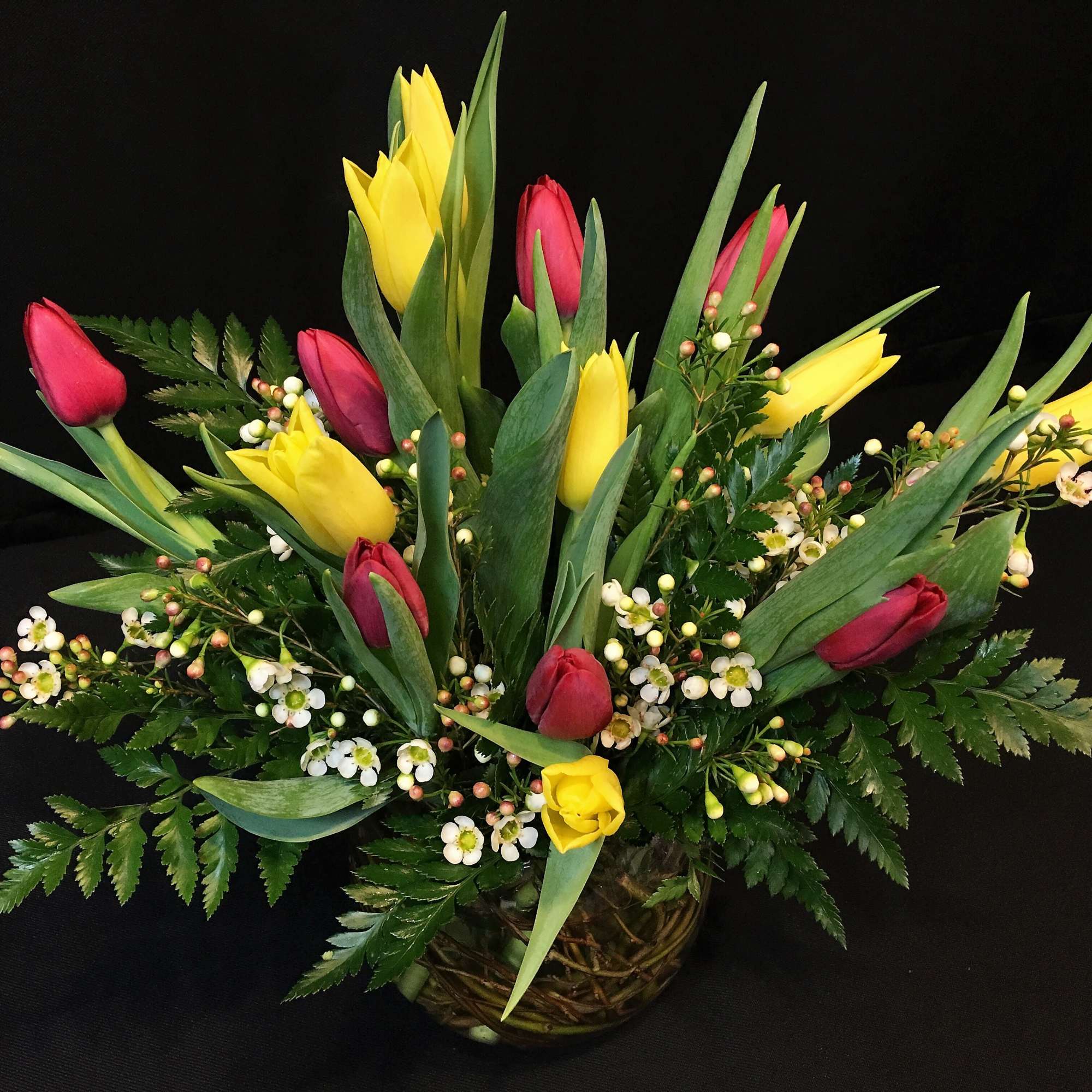 15 locally grown tulips mixed with a filler flower and fern. 