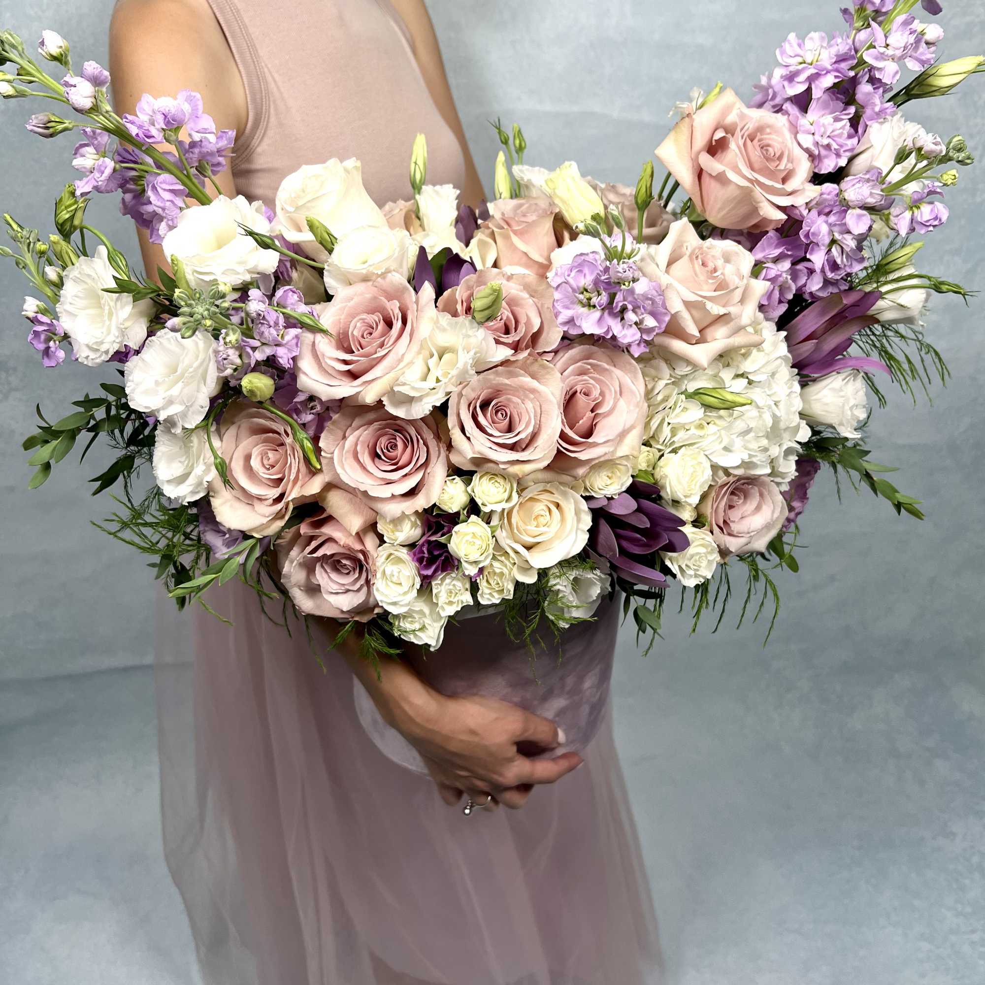 This elegant floral arrangement features a soft palette of blush pink roses
