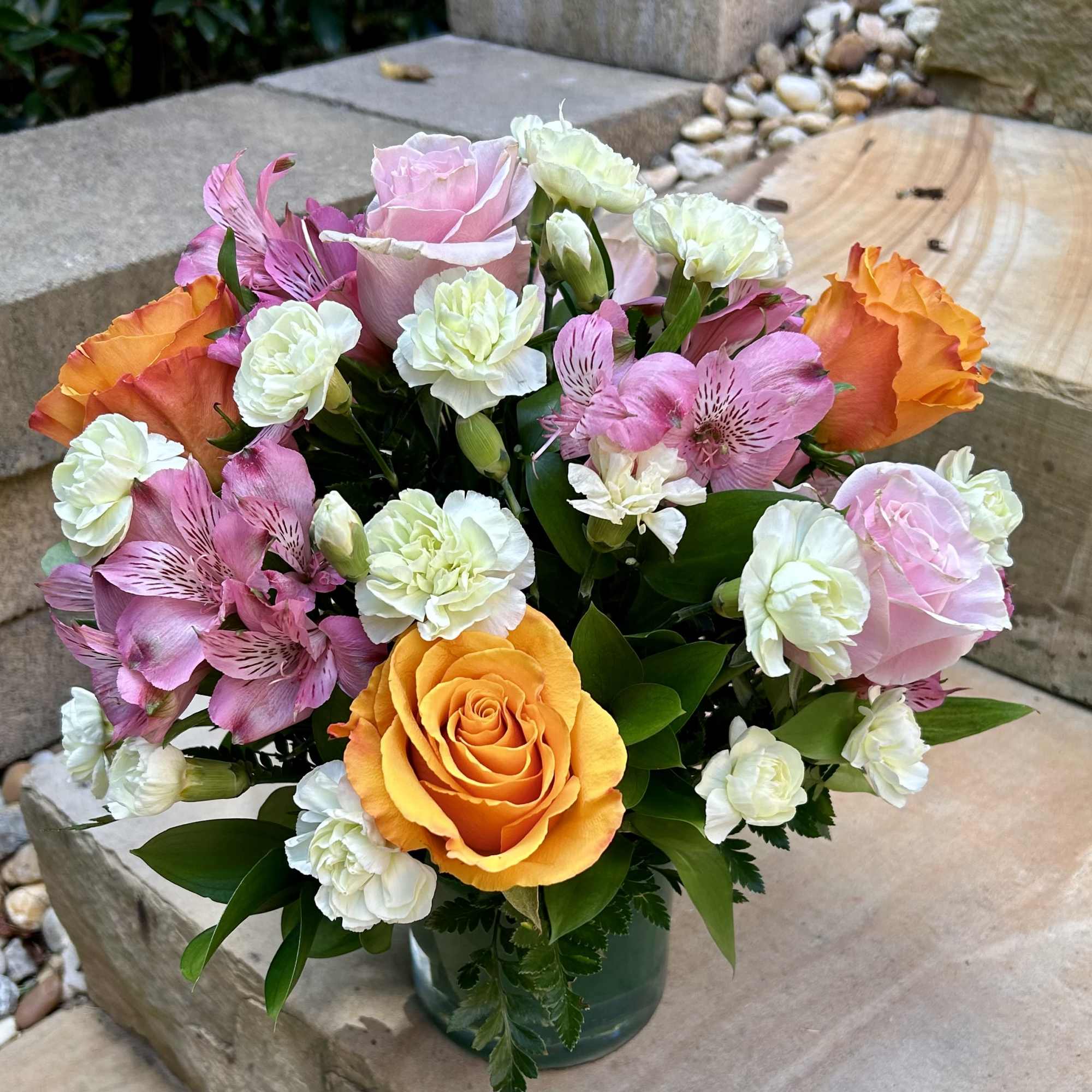 A spring colored bouquet of mini carnations, alstroemerias and roses in a