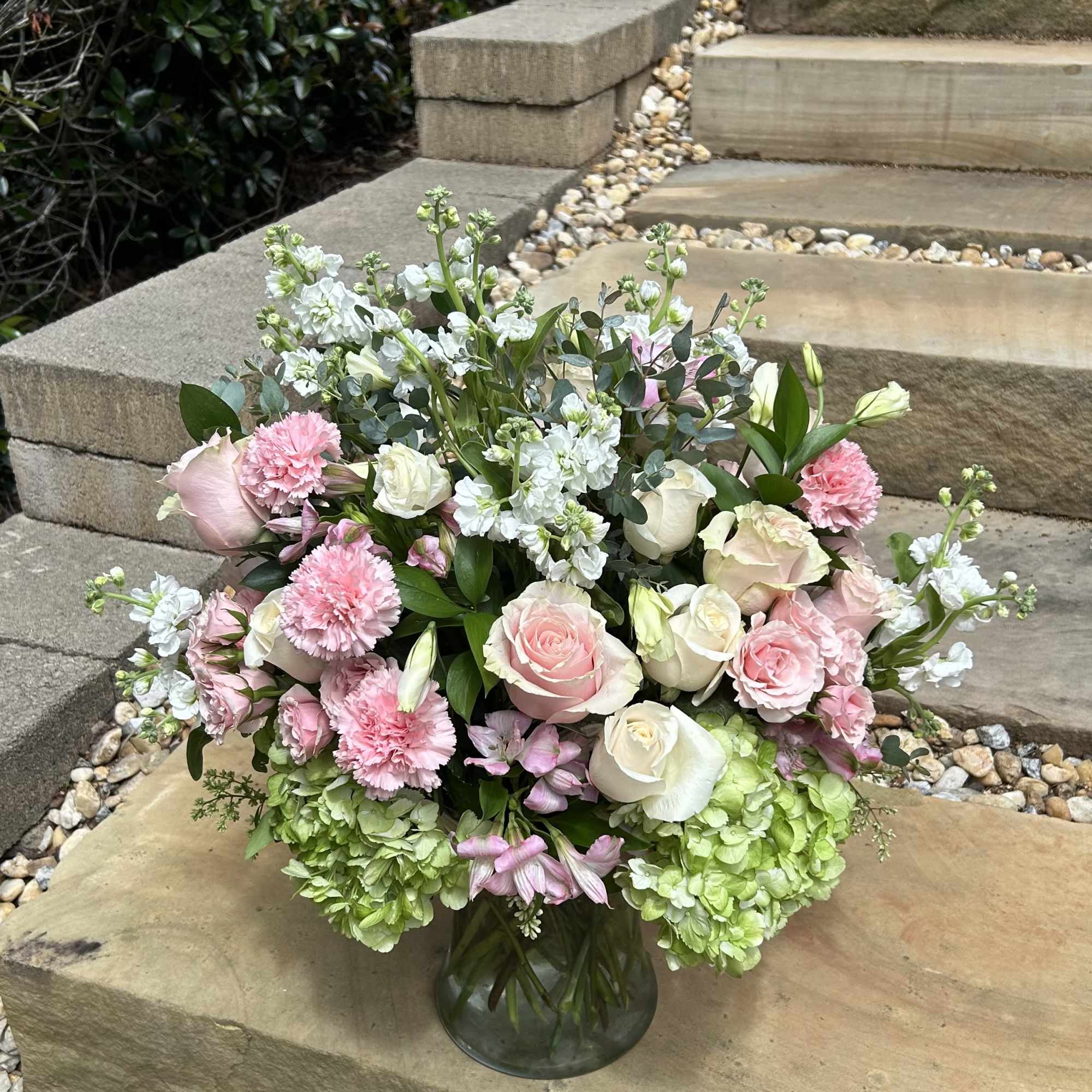 A grand bouquet of green hydrangeas, pink roses, carnations, alstroemerias, spray roses