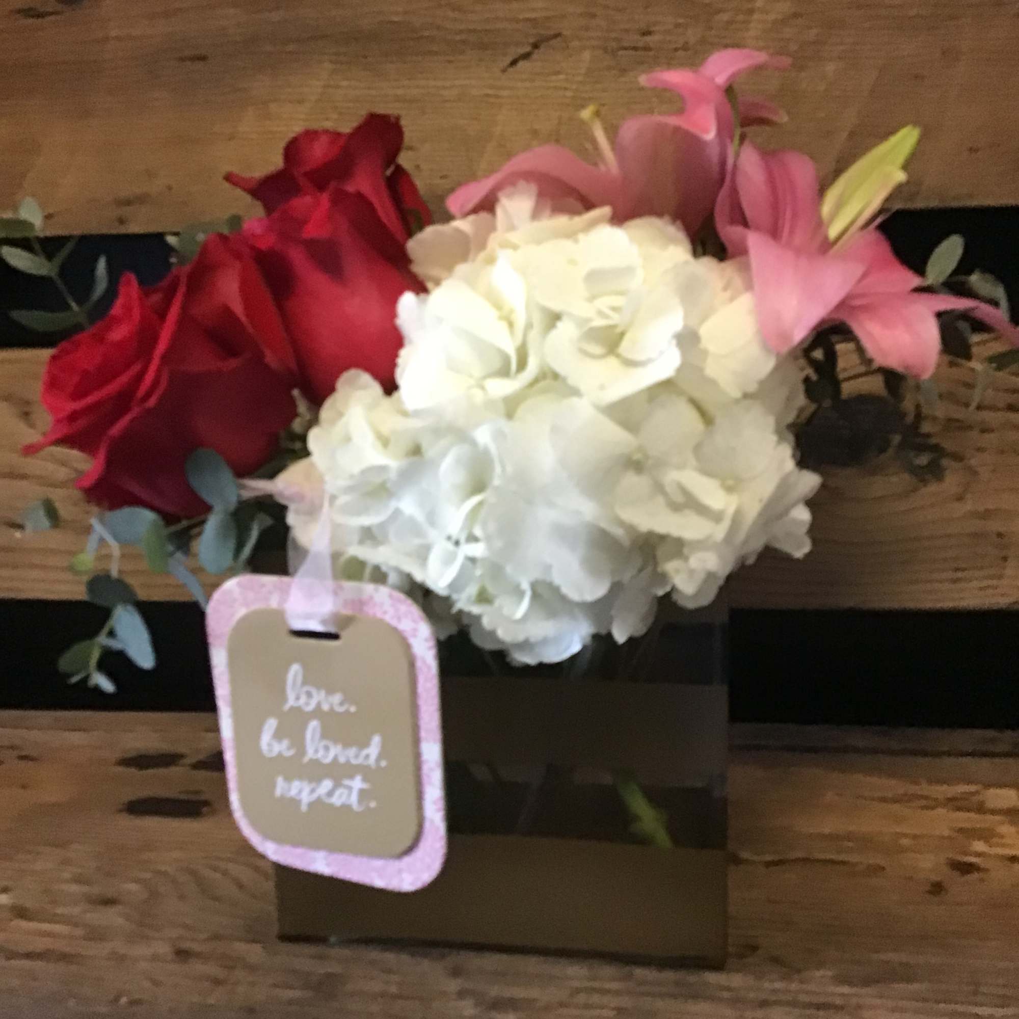 White hydrangea enveloping red roses with Lily&rsquo;s and eucalyptus with other filler