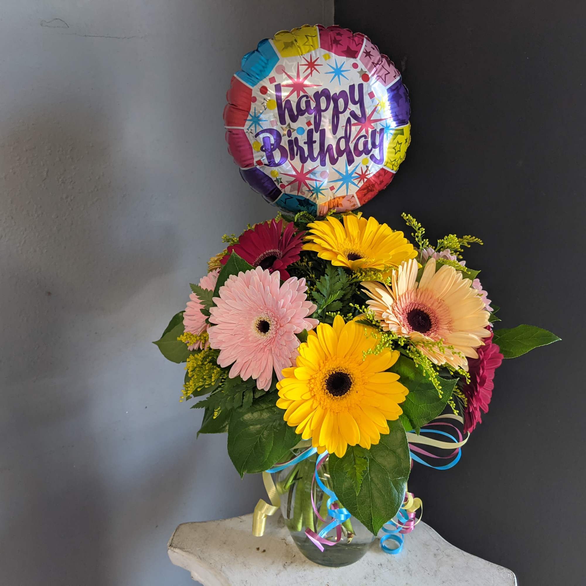 A dozen Gerbera Daisy paired with fun birthday items. 