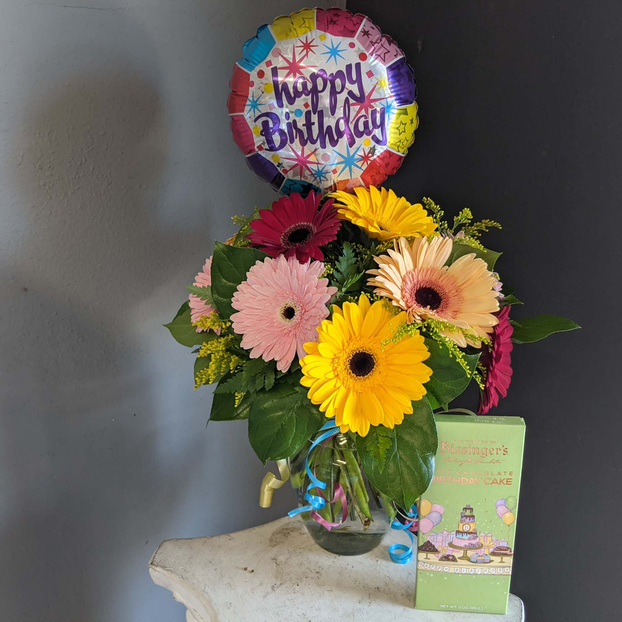 A dozen Gerbera Daisy paired with fun birthday items. 