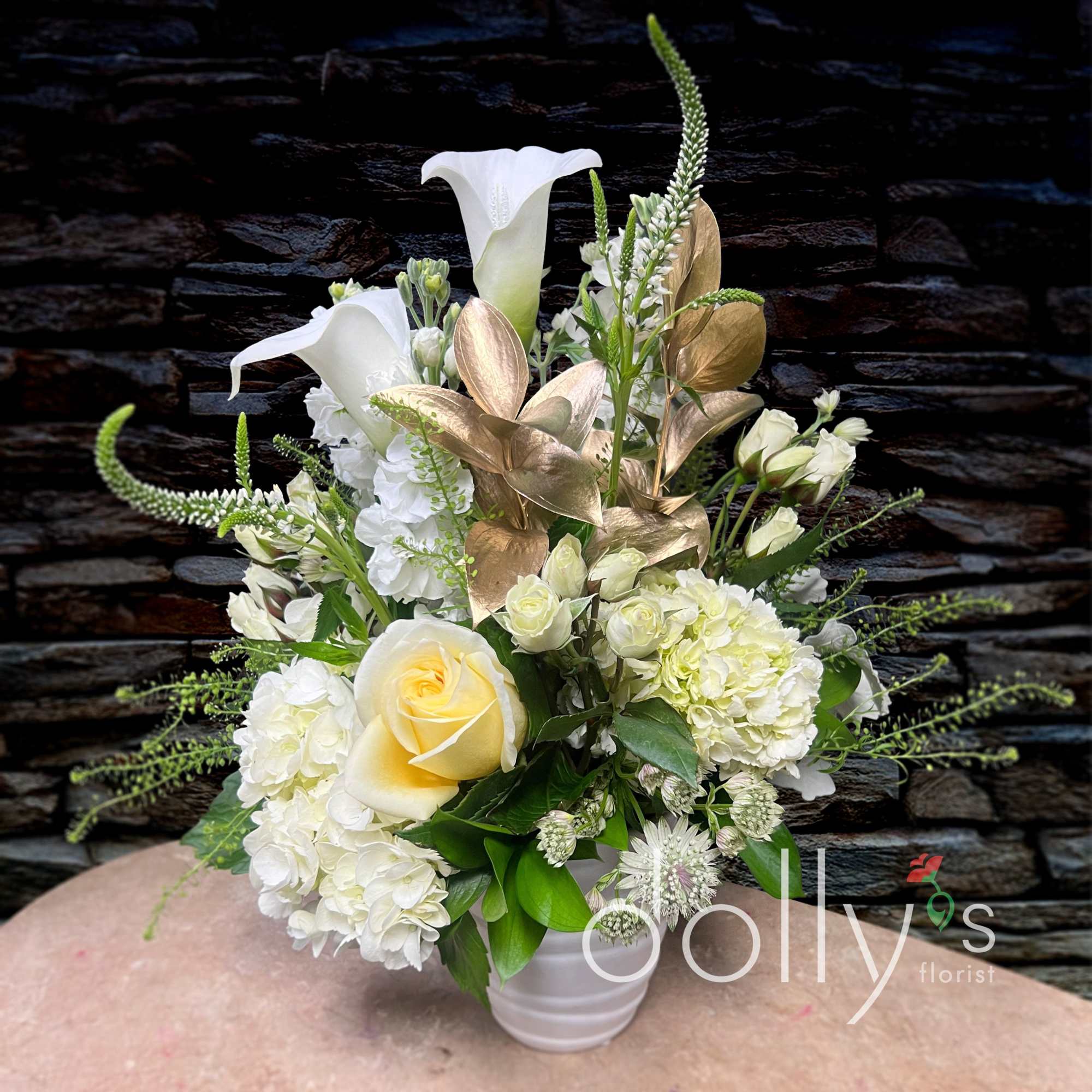 Composed of a bright white palette of calla lilies, hydrangeas, and spray