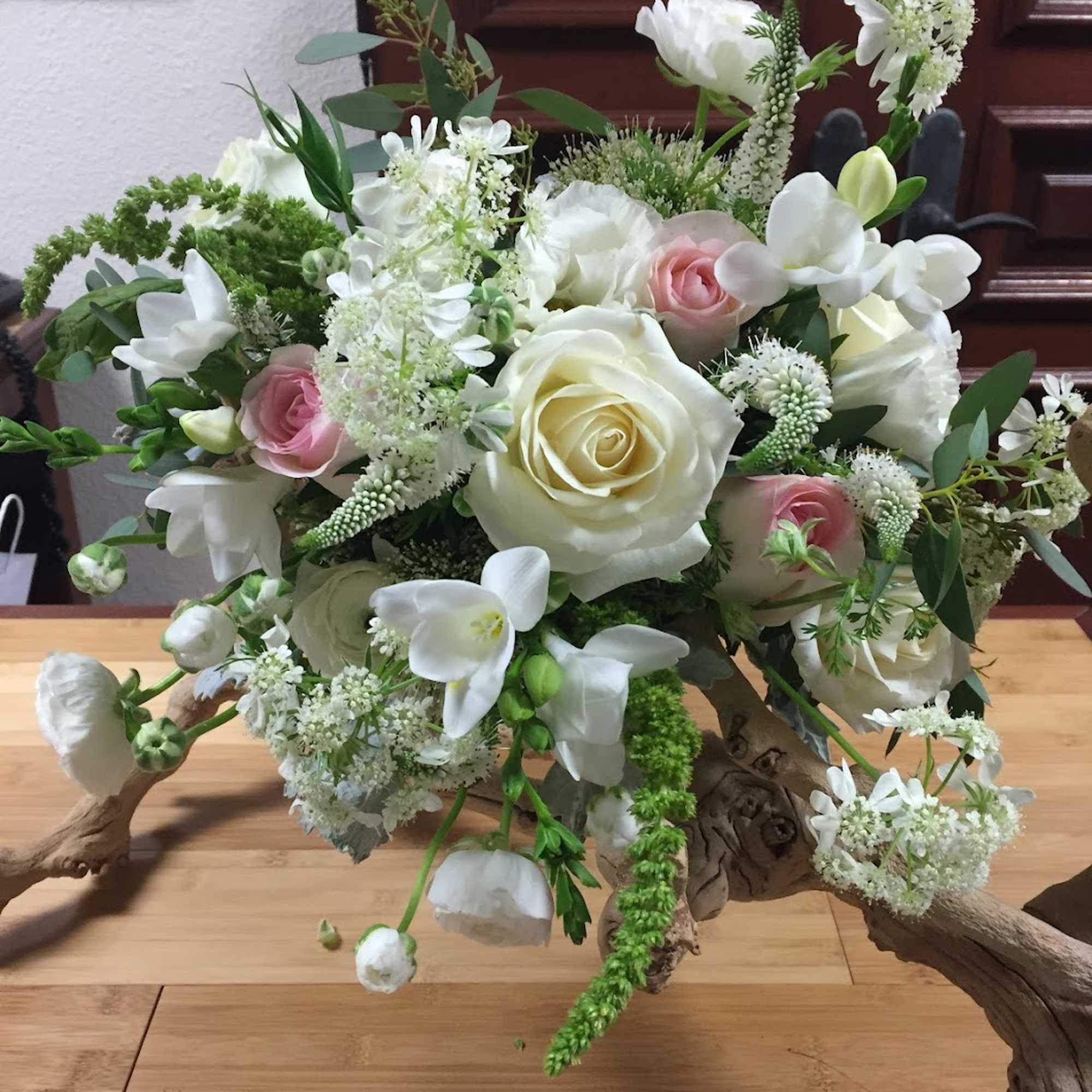 This beautiful, blushing wedding bouquet includes Roses, Lisianthus, Freesia, Ranunculus, and more