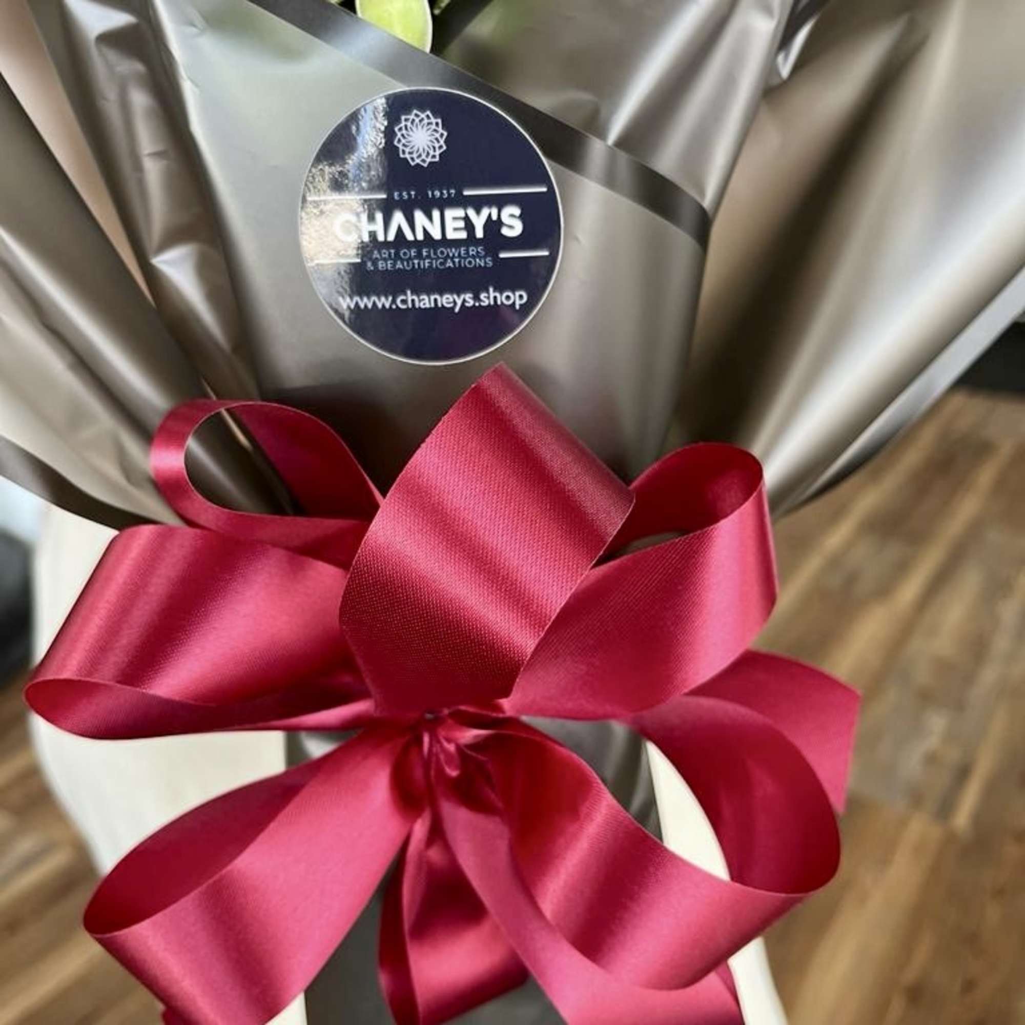 Exciting floral design wrap with 20 red roses topped with a hand