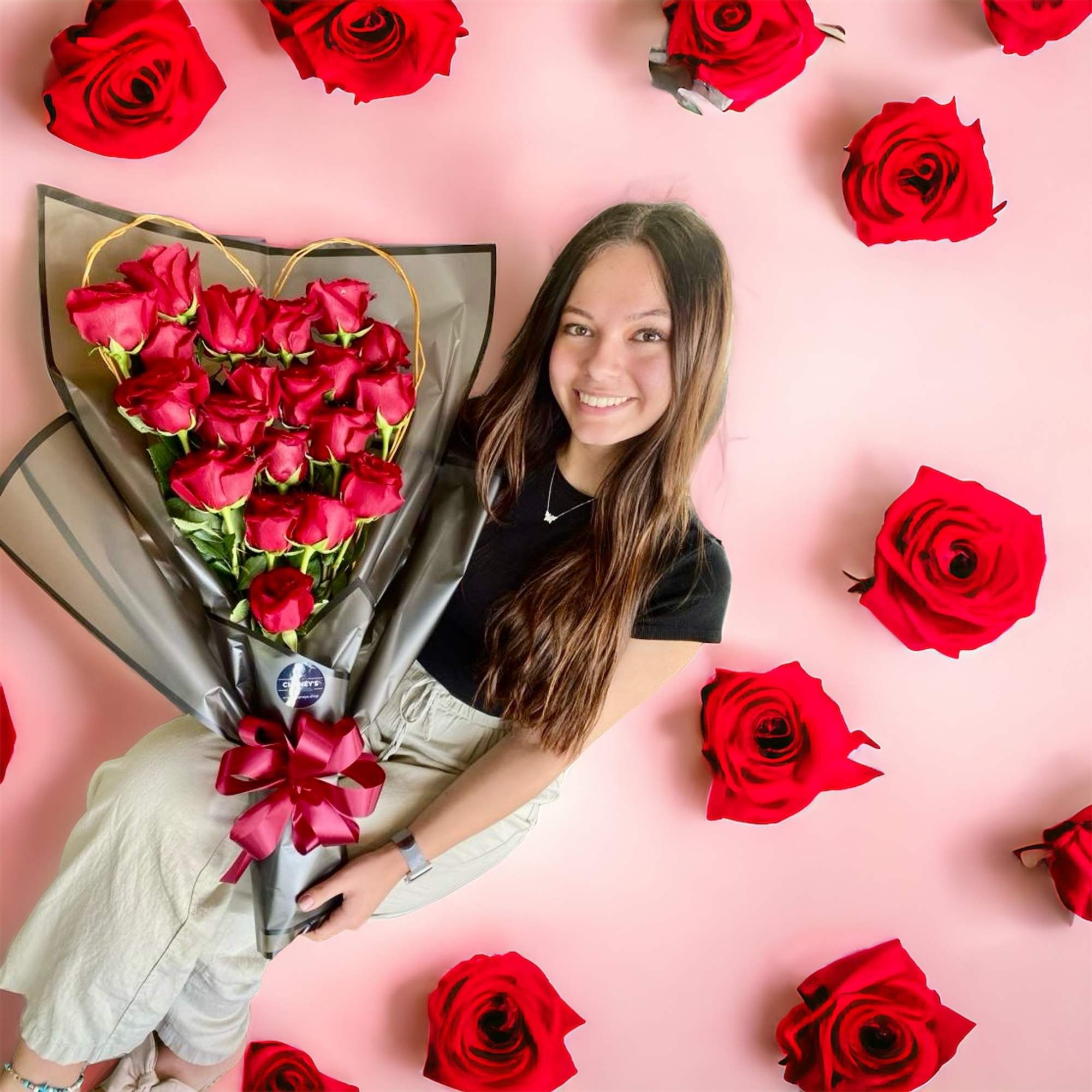 Exciting floral design wrap with 20 red roses topped with a hand