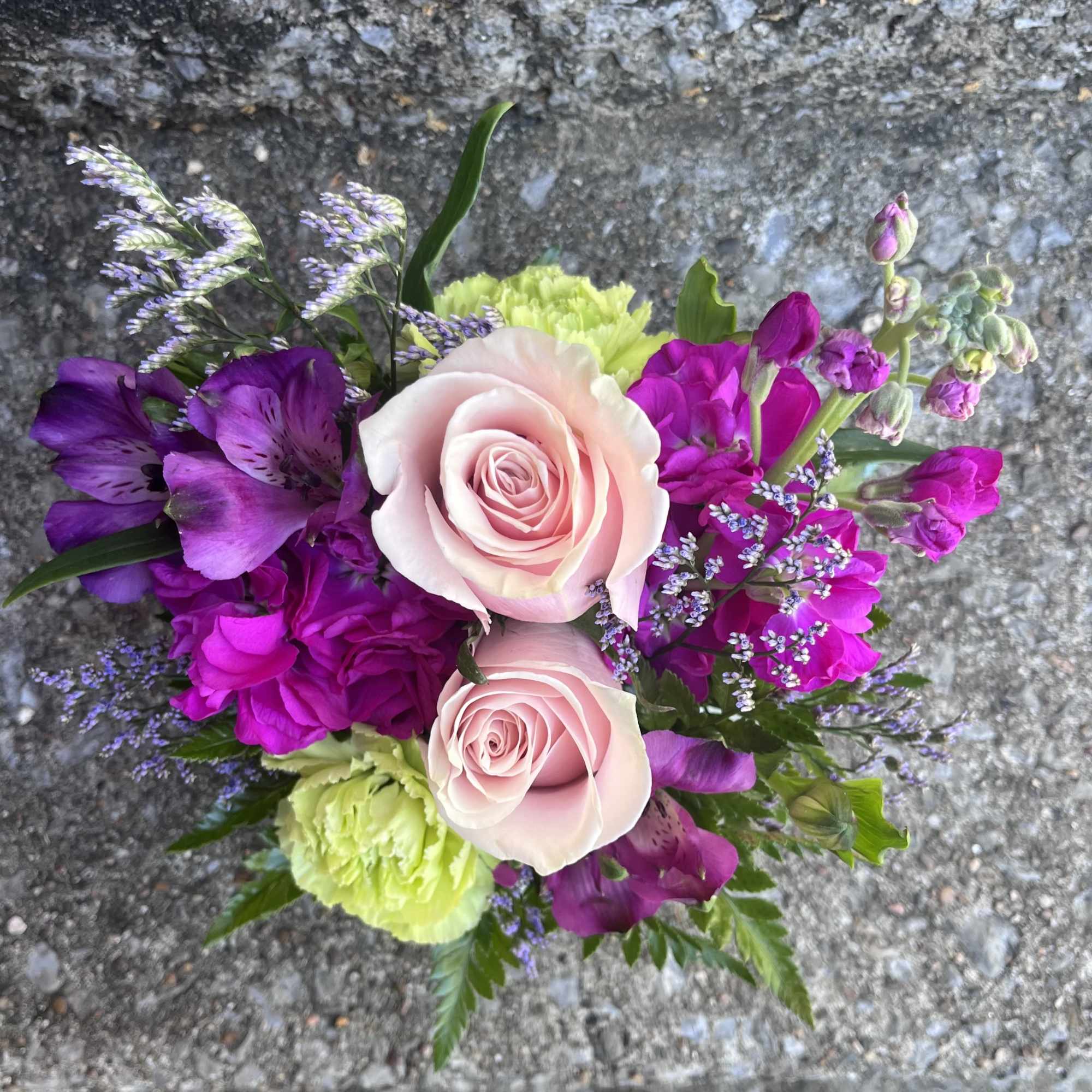 This arrangement has roses, stock, carnations, alstroemeria, misty and greenery. 
