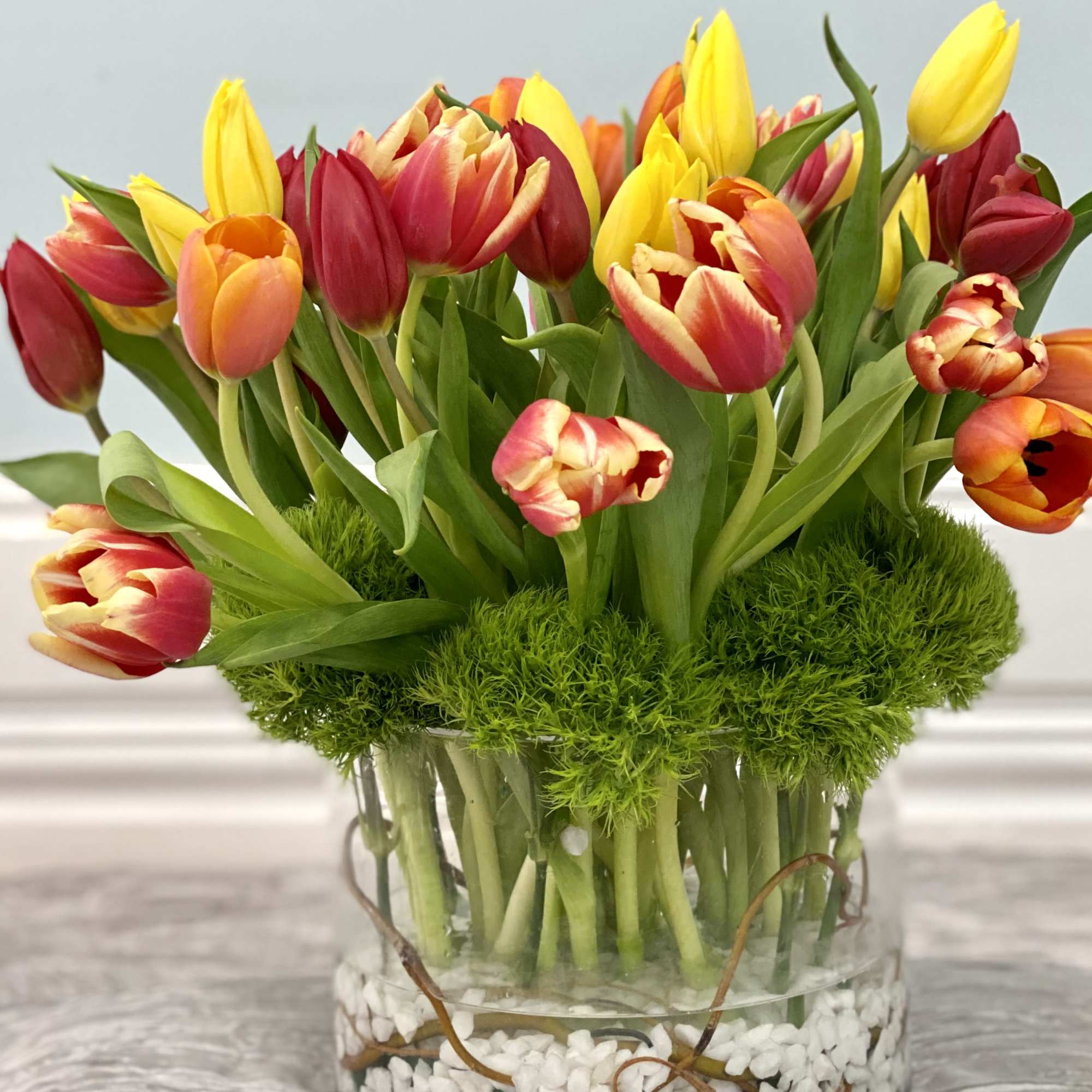 Welcome the flourishing season of spring with a bountiful yet modern arrangement