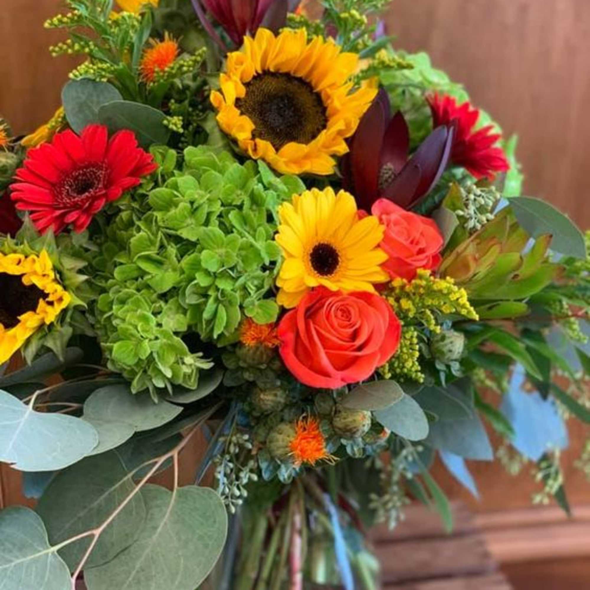 Bright colorful blooms in a sleek glass cube. This arrangement is perfect