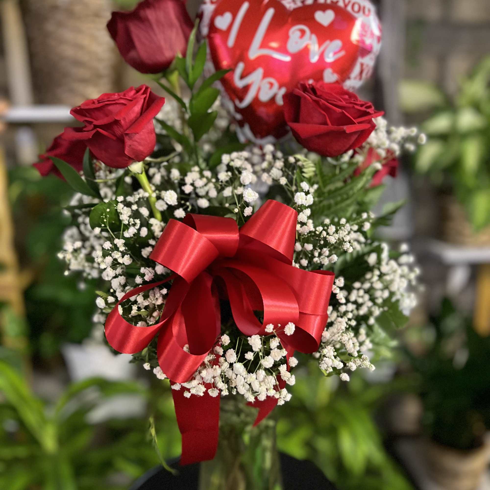 half dozen 6 roses in greenery in vase 