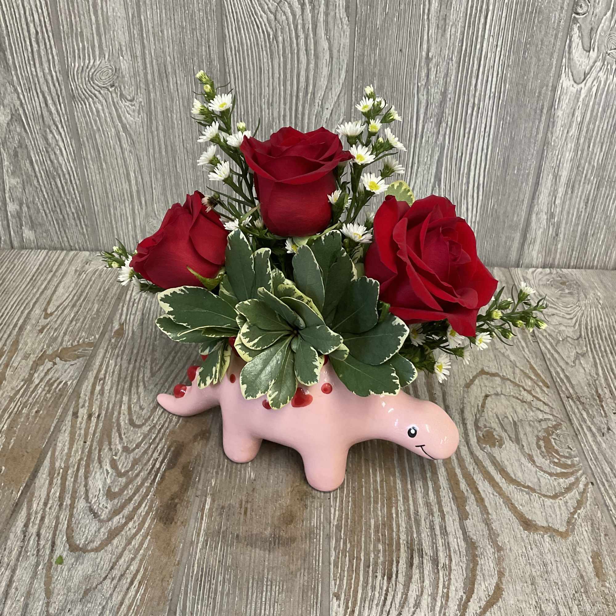 This sweet arrangement in a ceramic keepsake stegosaurus container is perfect to