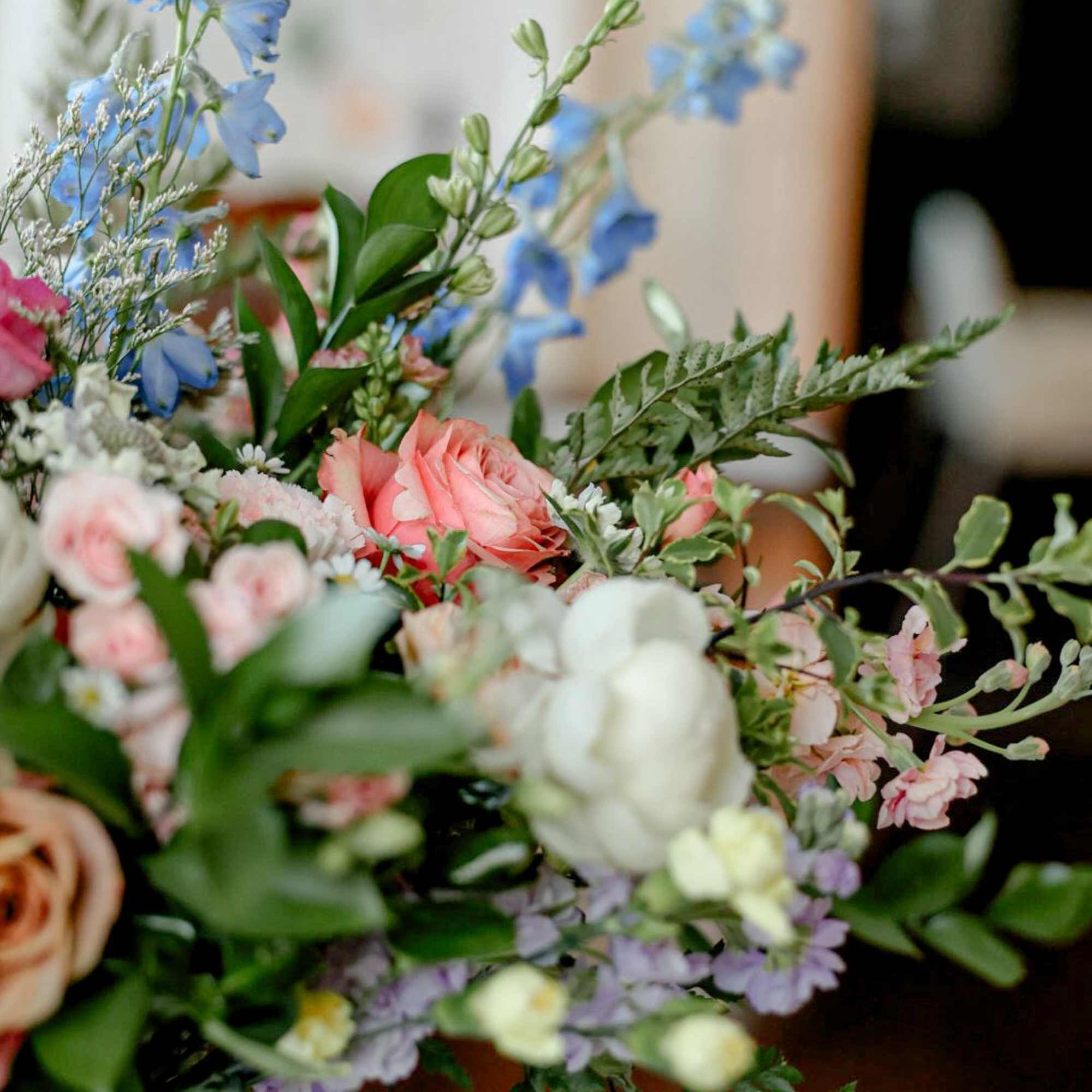 A truly lovely arrangement of roses, delphinium, stock, wildflowers and greens. 