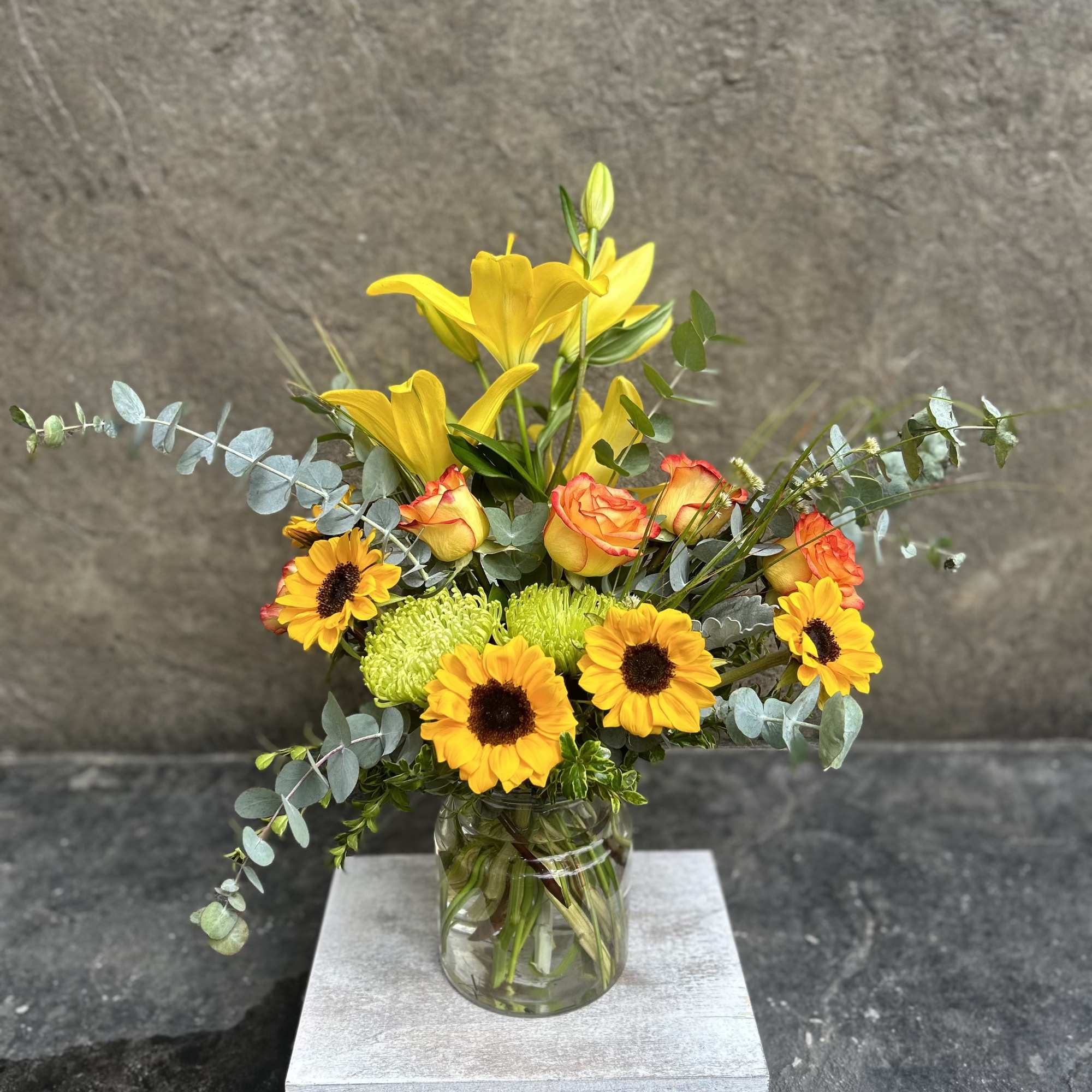 Bright cheerful blooms, sunflowers, roses and Lillies with fragrant eucalyptus, and grasses.