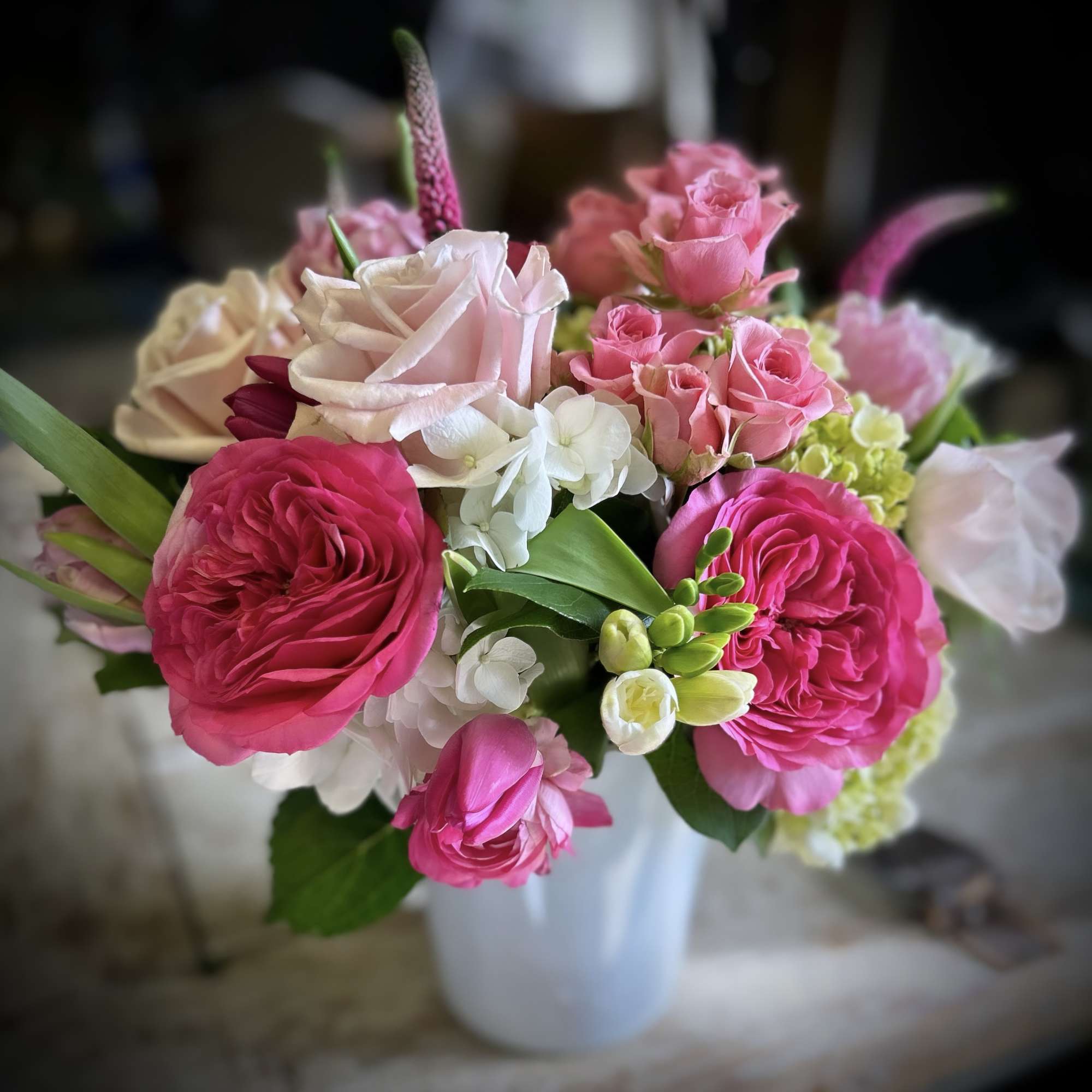 A sweet arrangement of spray roses, roses, hydrangea, tulips, and anemones. 