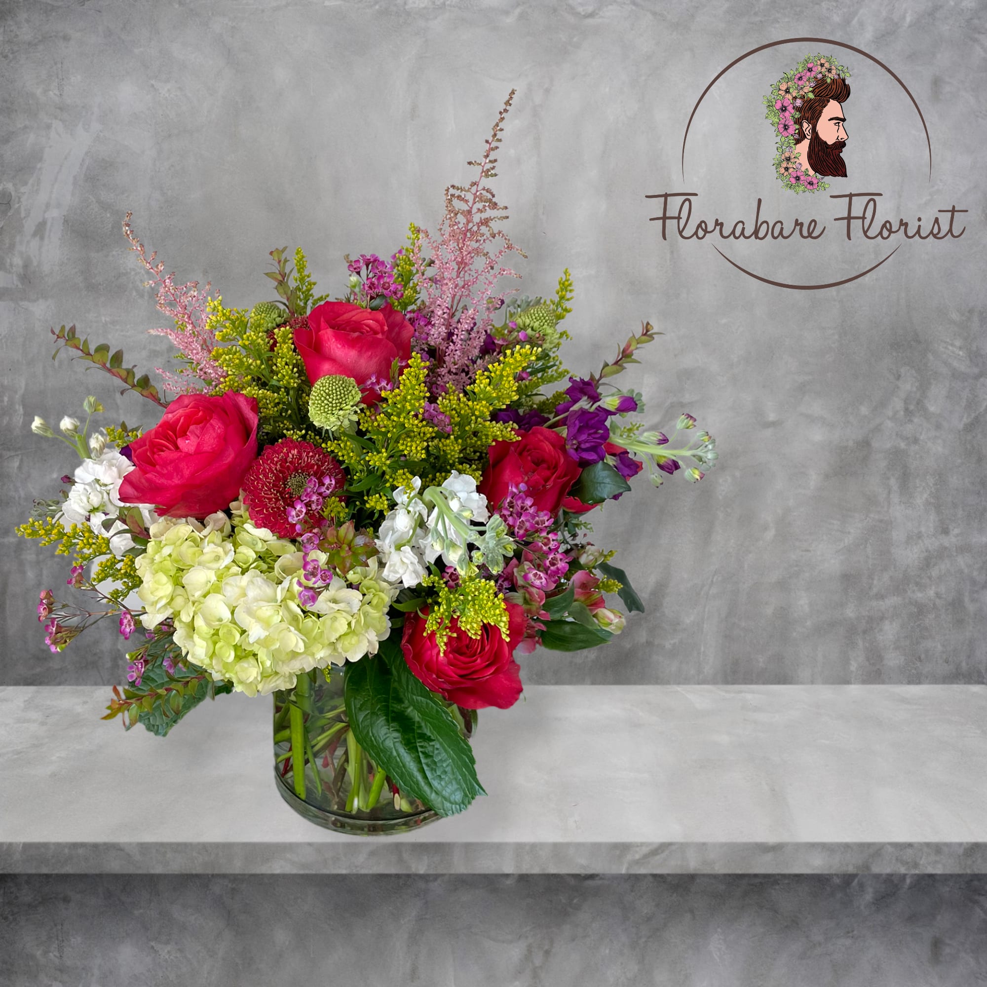 Lush floral design filled with vibrant colors. Consisting of seasonal flowers and
