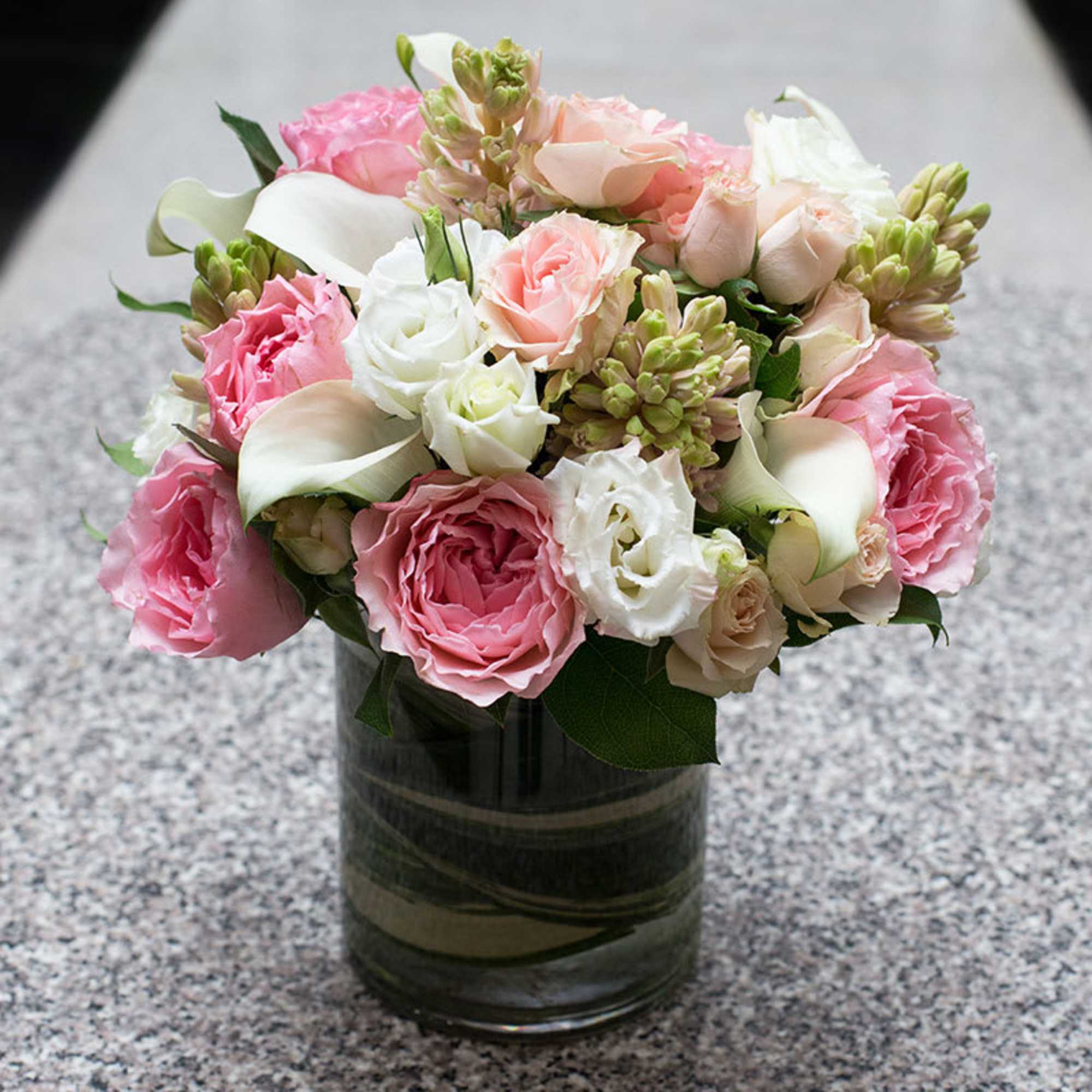 This arrangement includes peach, soft pink and white florals. It includes hyacinth