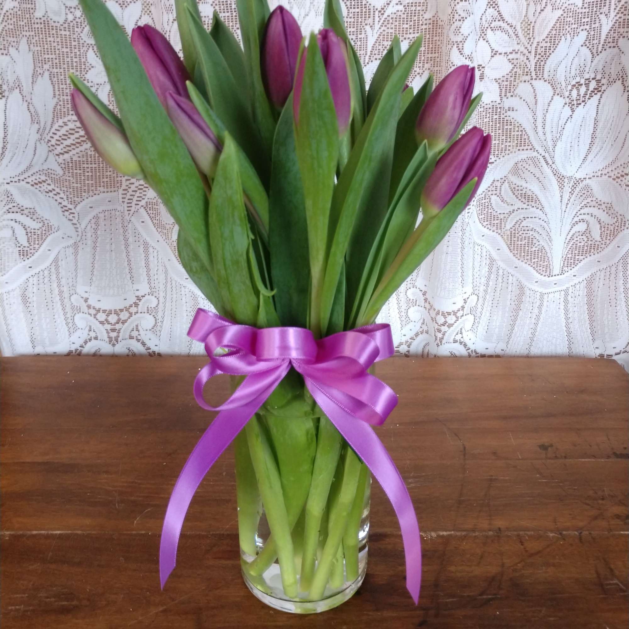 Purple Tulips arranged in a glass vase.
