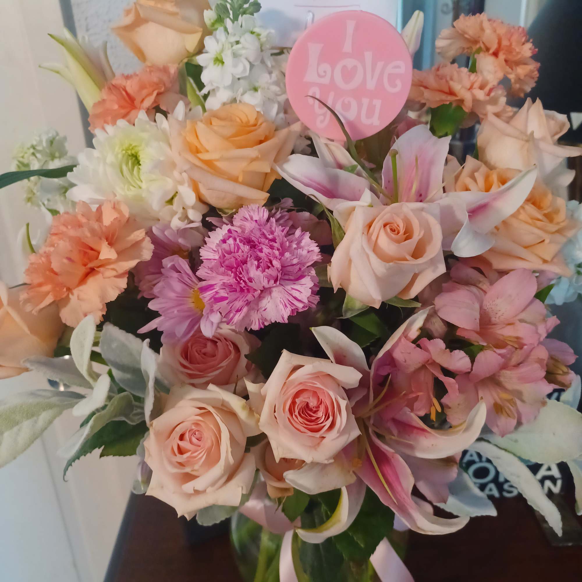 A pretty pastel mixture of "artificial and fresh chrysanthemums, lillies and roses
