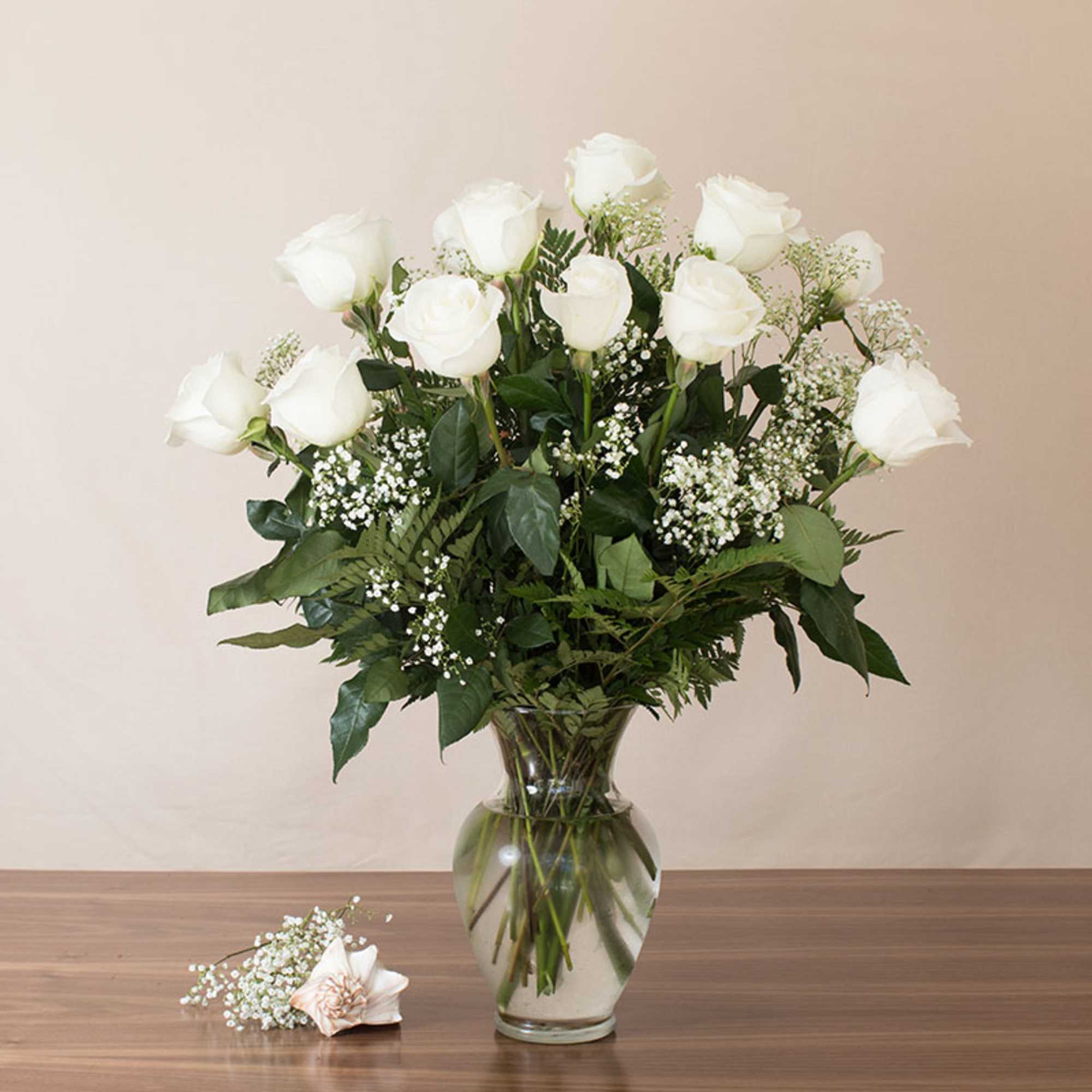 A dozen premium extra long white roses, beautifully accented with lush greens