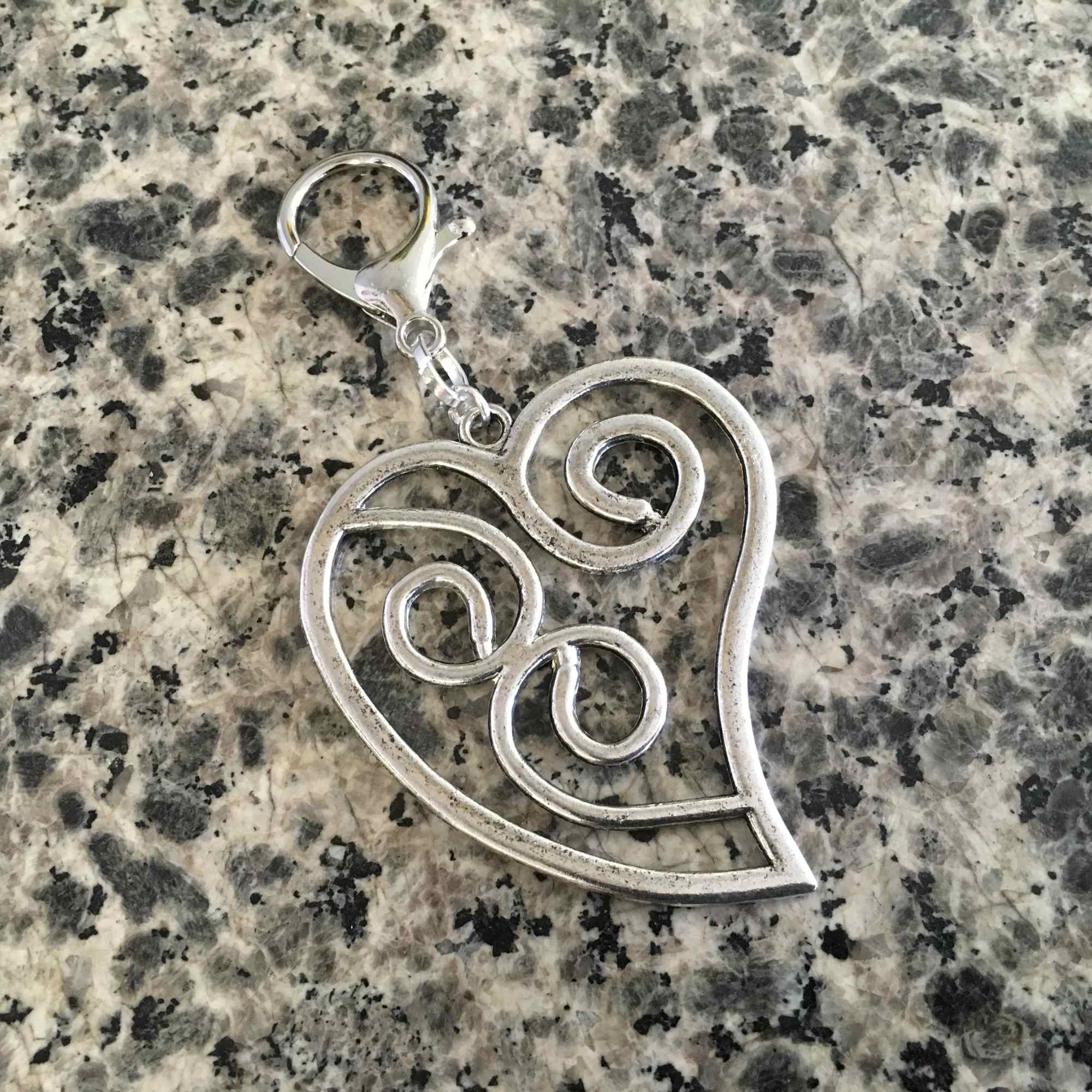 6 red roses arranged in glass vase w/ lg. silver heart pull