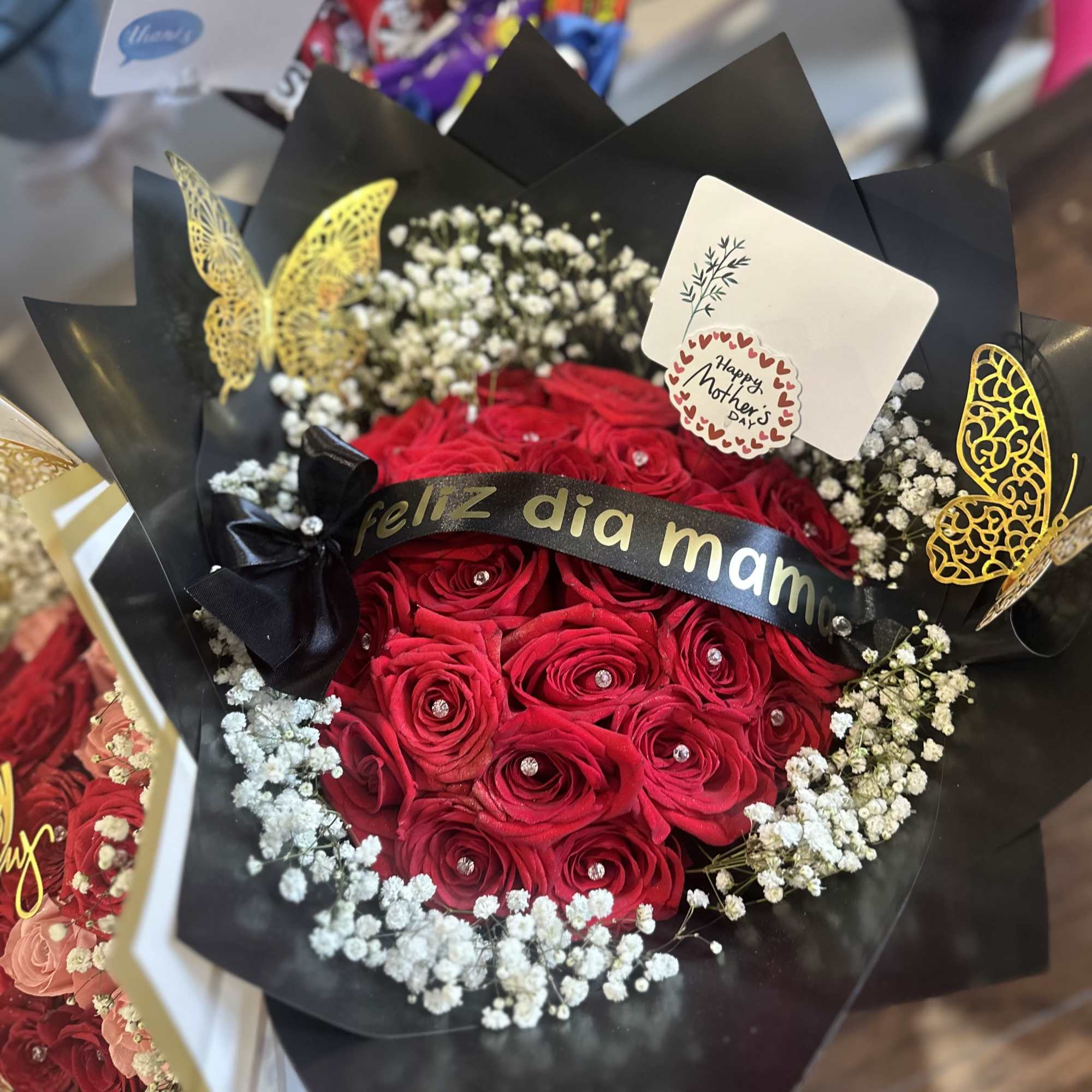 A bouquet of 24 red roses with a personalized ribbon and wrapping