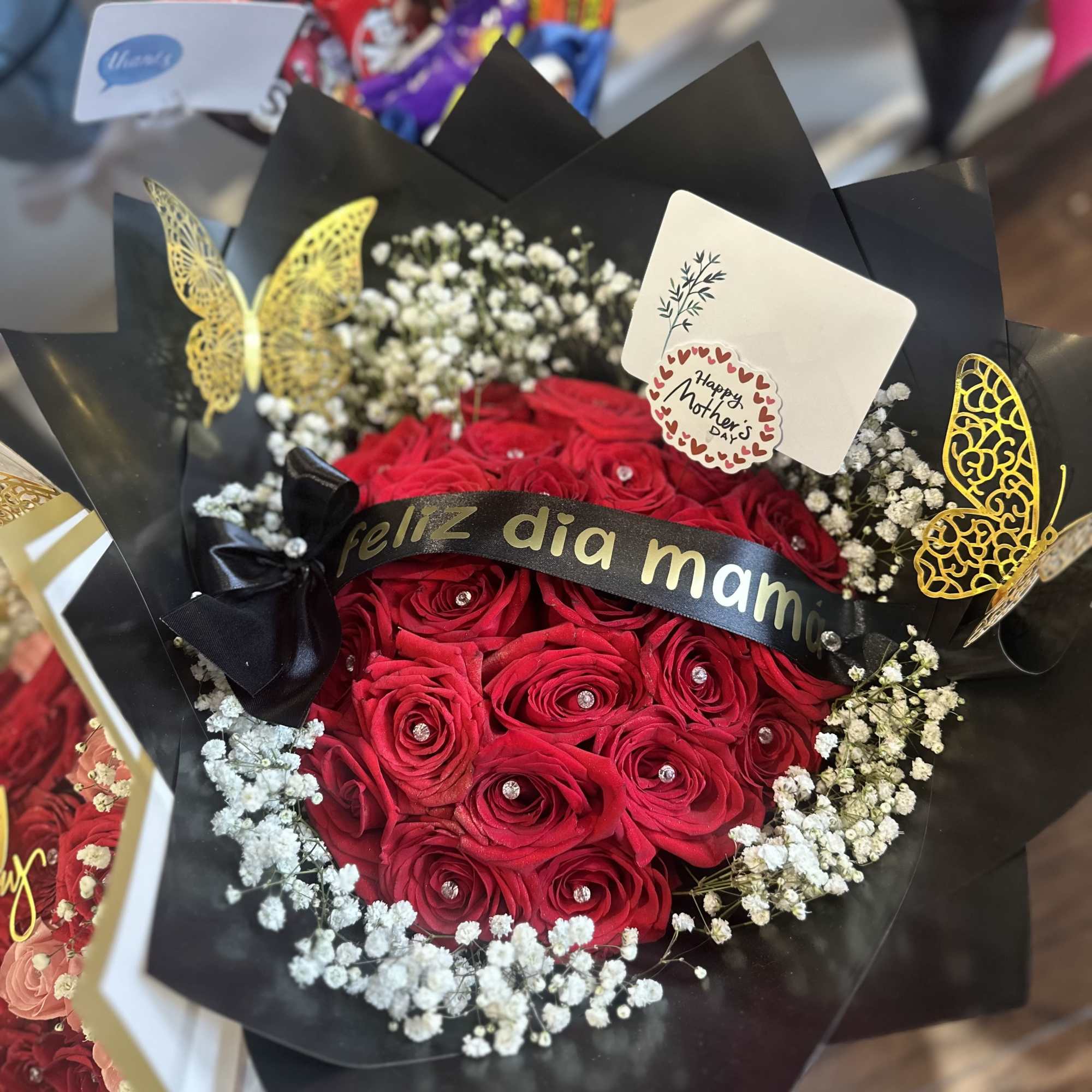 A bouquet of 24 red roses with a personalized ribbon and wrapping