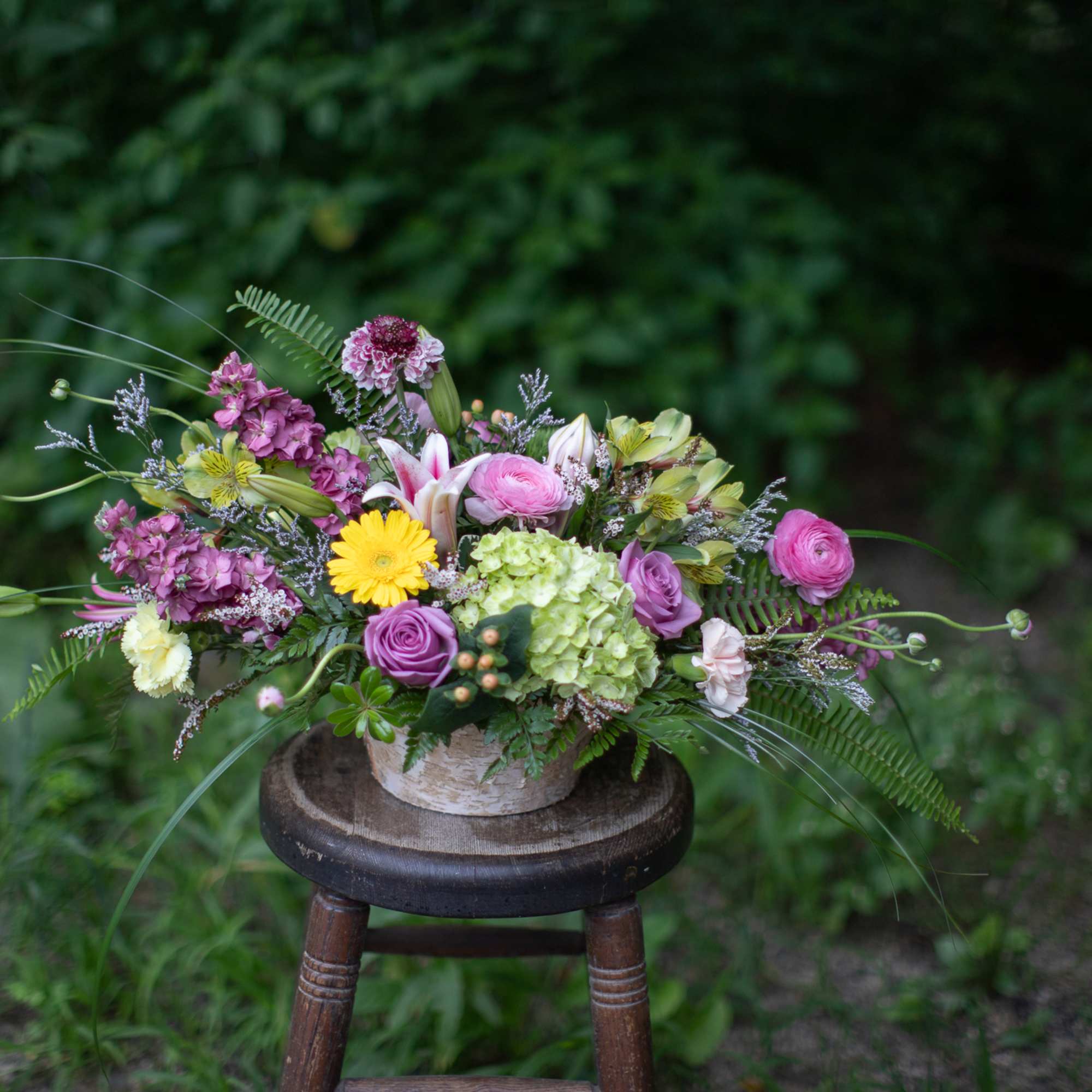 Elegantly designed garden style flowers arranged in a shabby chic novelty birch