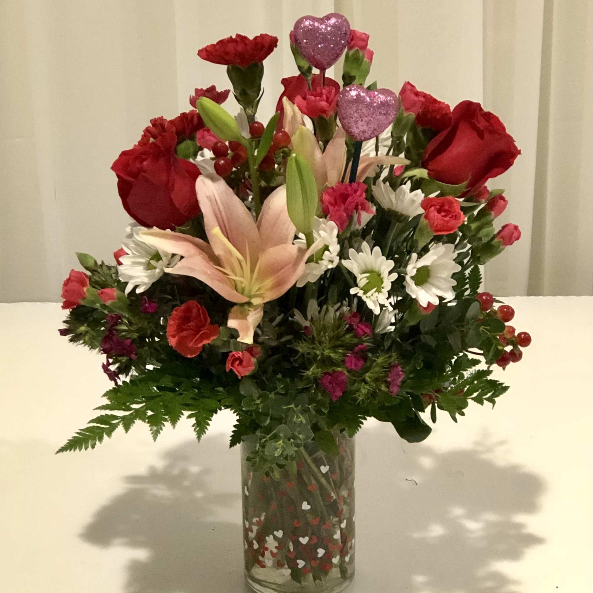 Beautiful assortment of fresh blooms beautifully designed with a valentines flair.