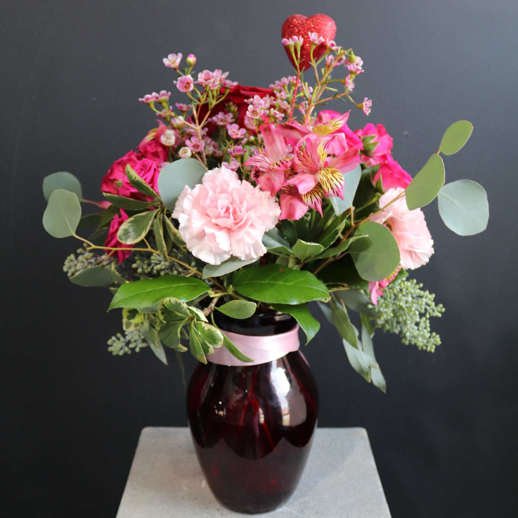 What a warm loving arrangement decked out in pinks and reds!
