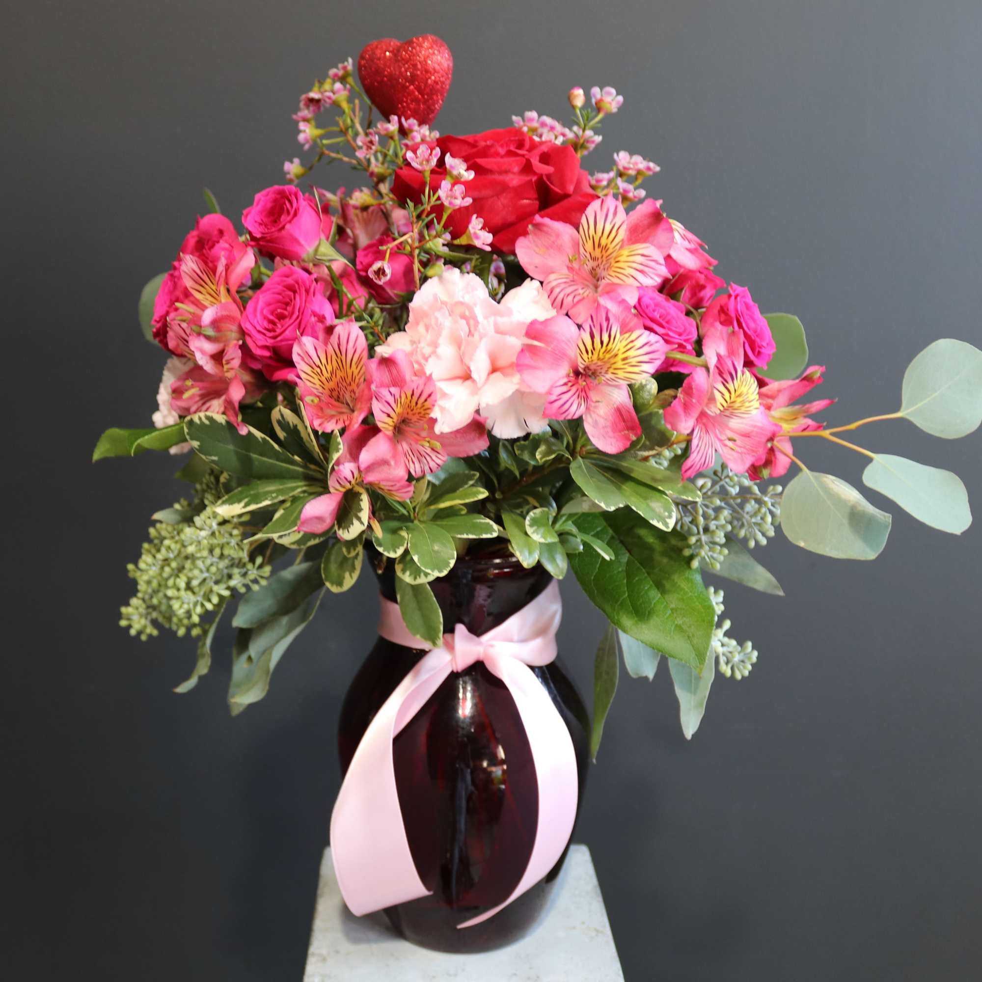 What a warm loving arrangement decked out in pinks and reds!