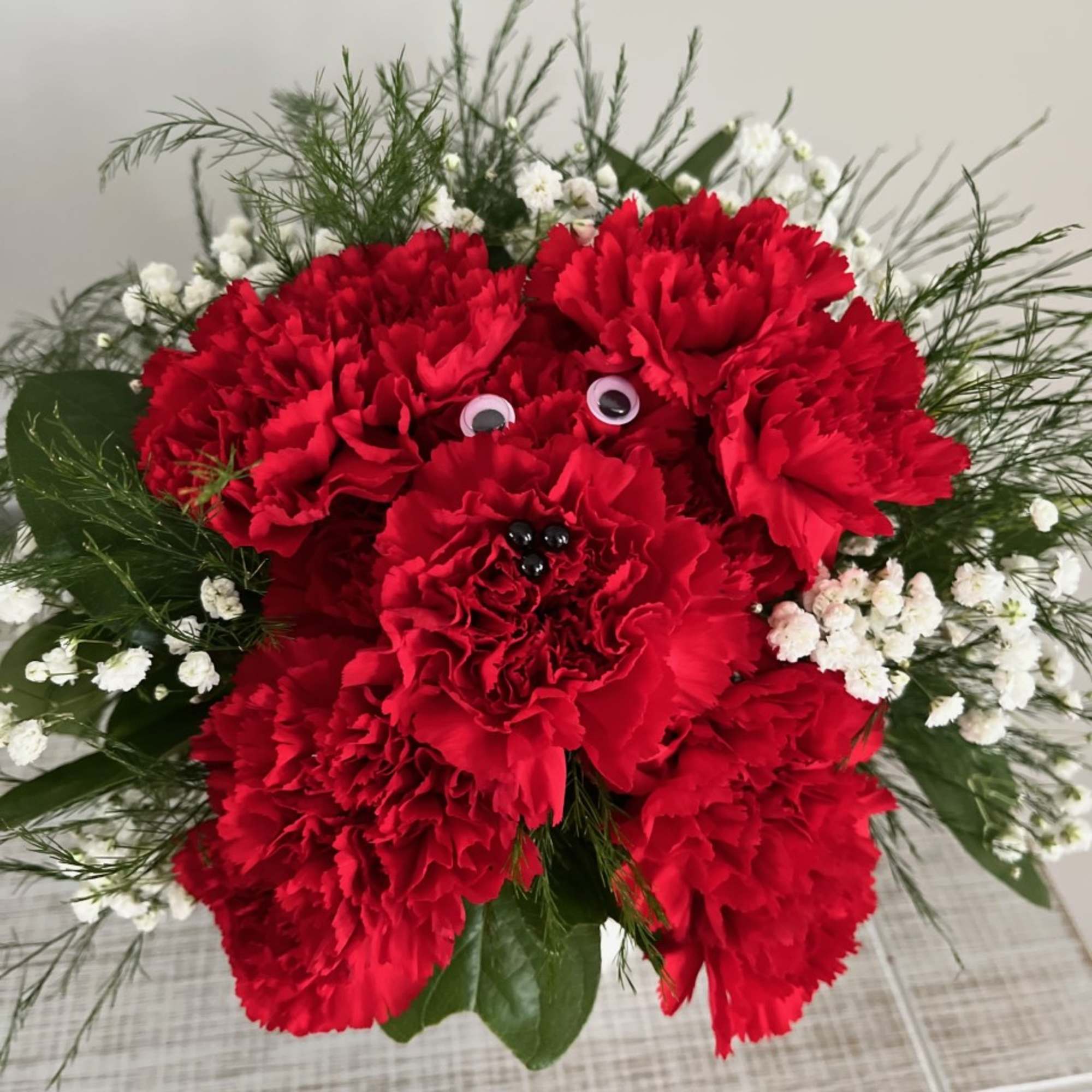 This cute carnation arrangement is sure to bring joy to the recipient!