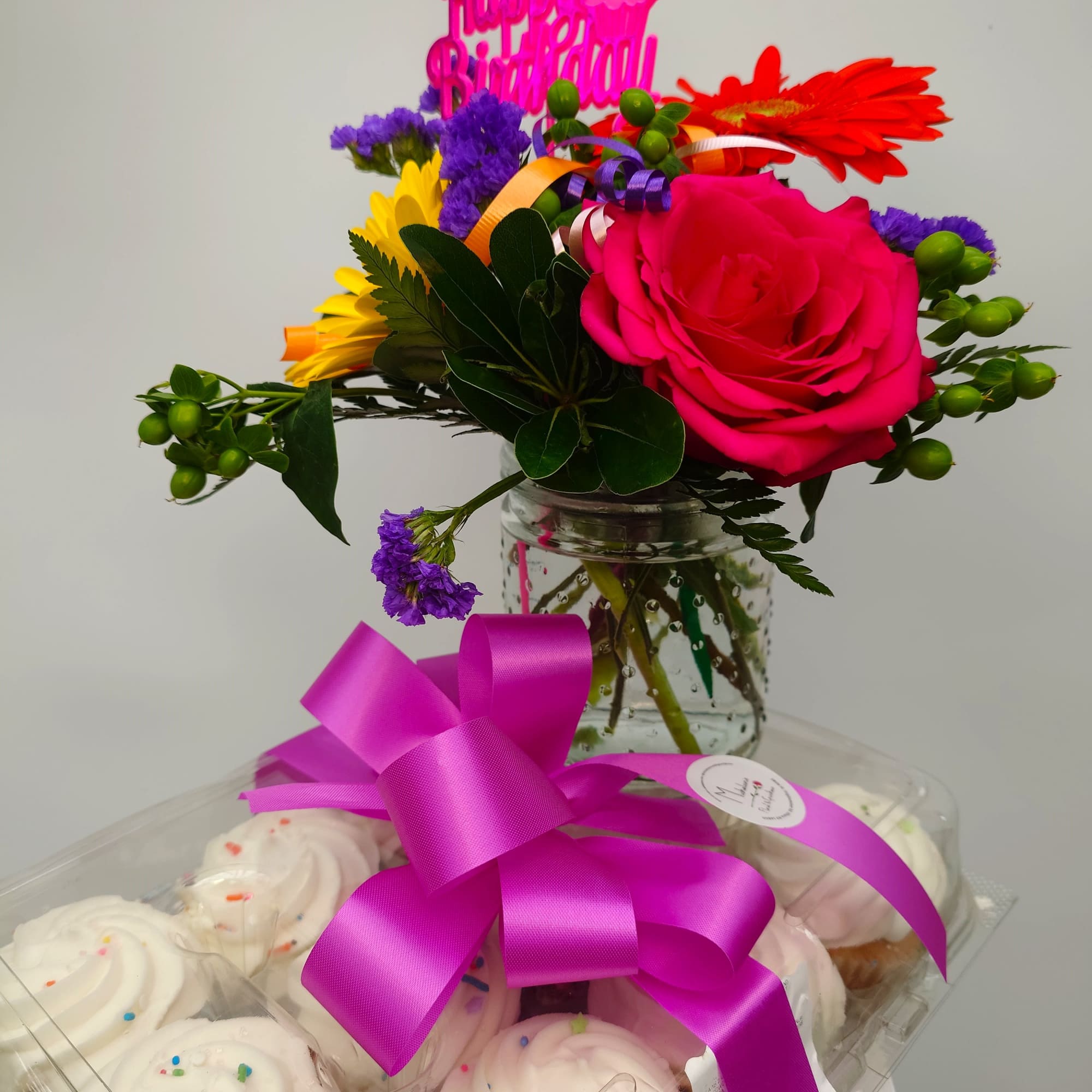 Indulge in a delightful dozen cupcakes accented by a small floral design.