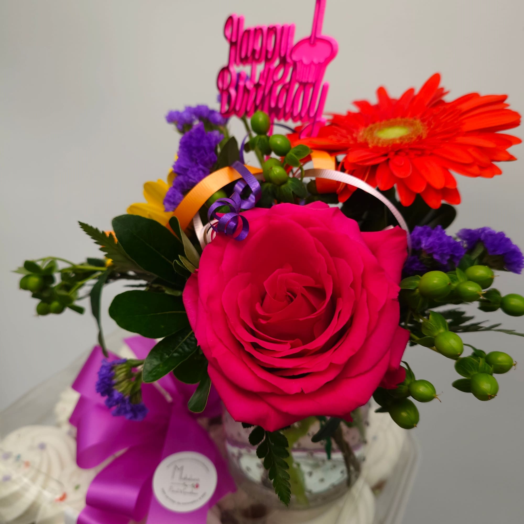 Indulge in a delightful dozen cupcakes accented by a small floral design.