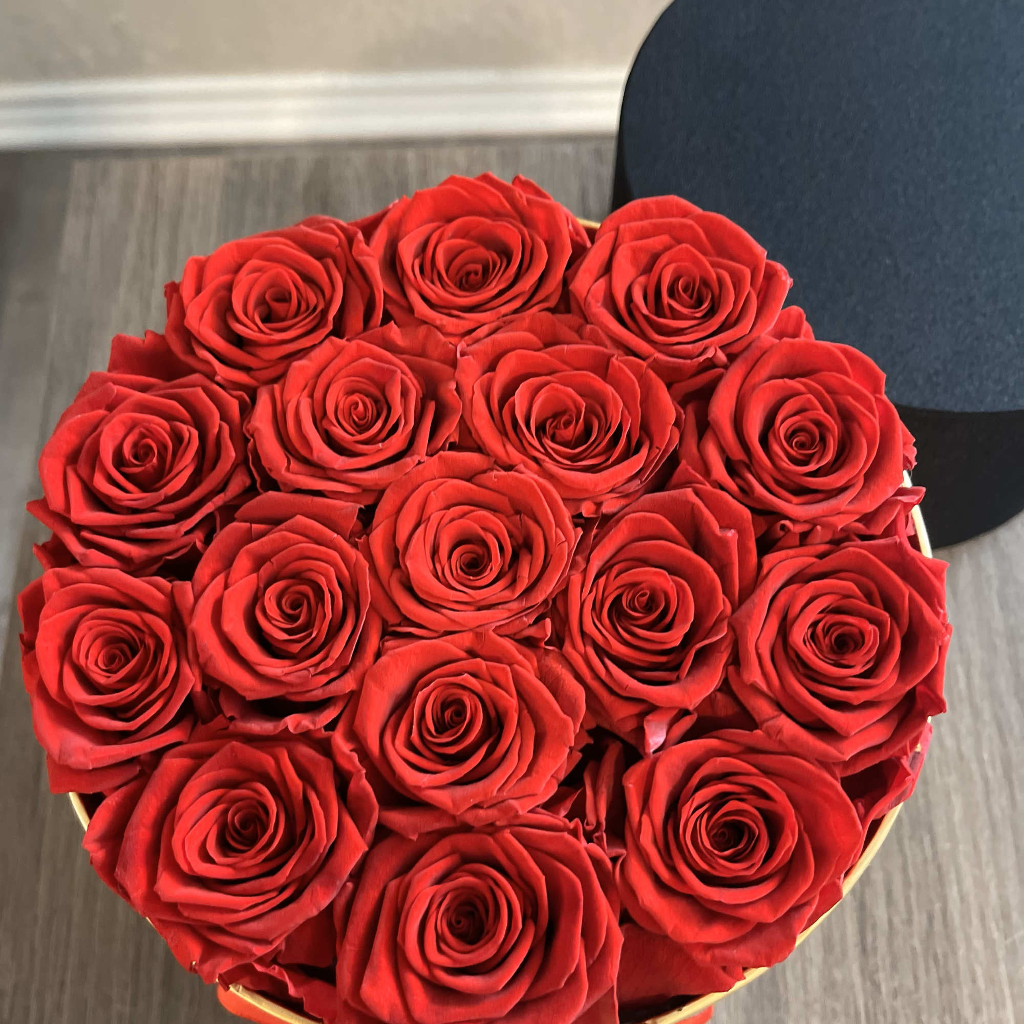 Stunning cylinder shaped box with 16 preserved  real red roses that
