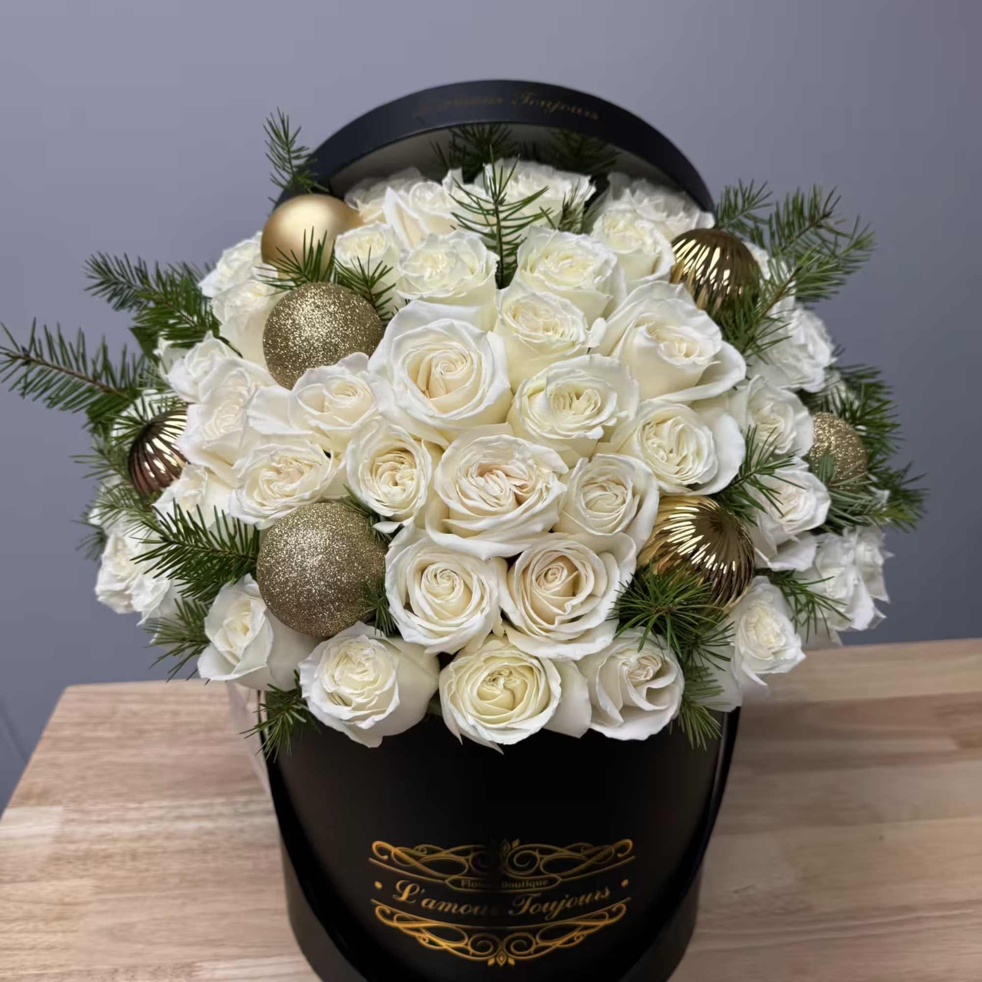 
50 white roses with ornaments and pine in our Signature box